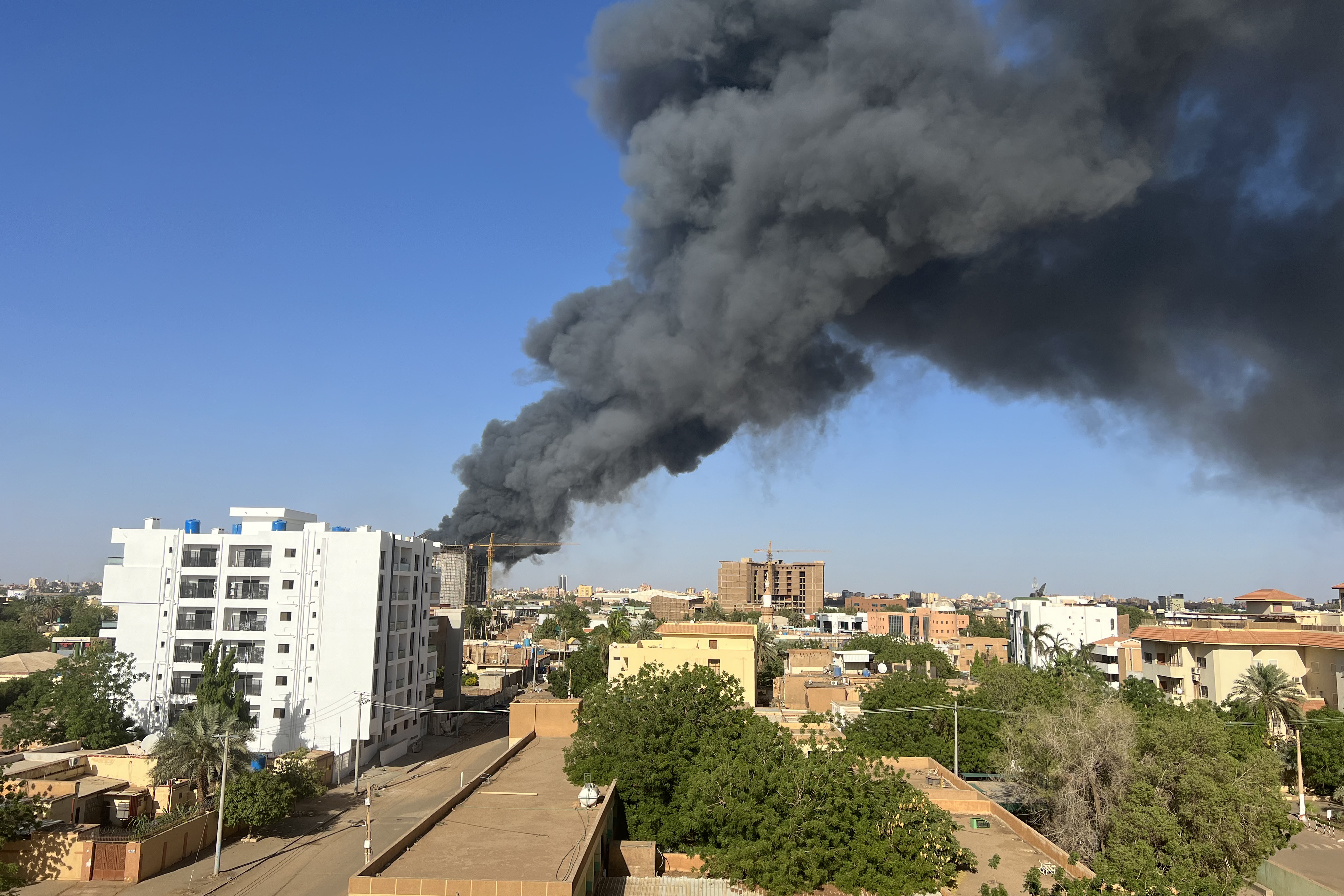 A column of smoke rises above Khartoum’s skyline near its international airport