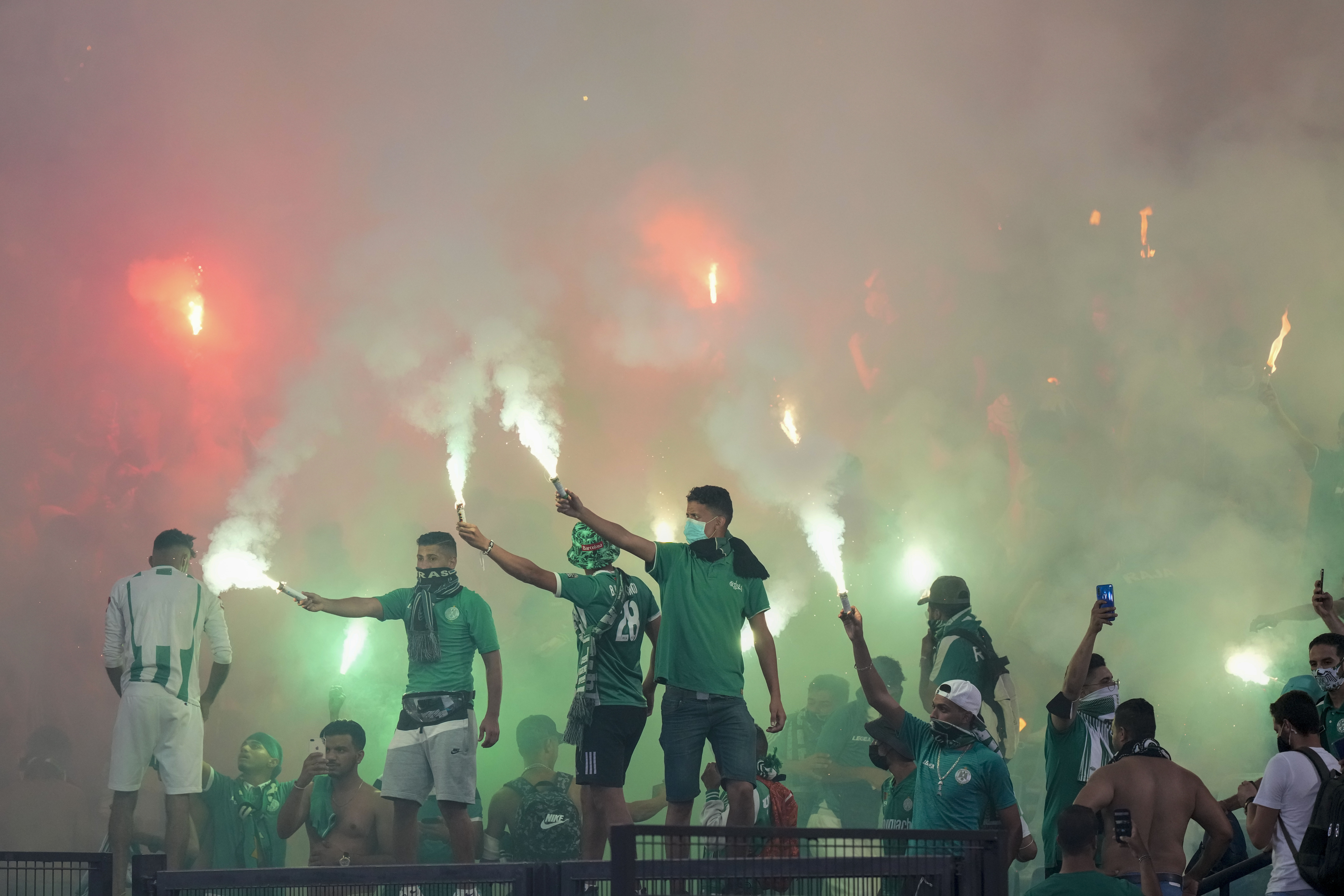 Raja Casablanca supporters burn flares during a friendly match between Roma and Raja Casablanca