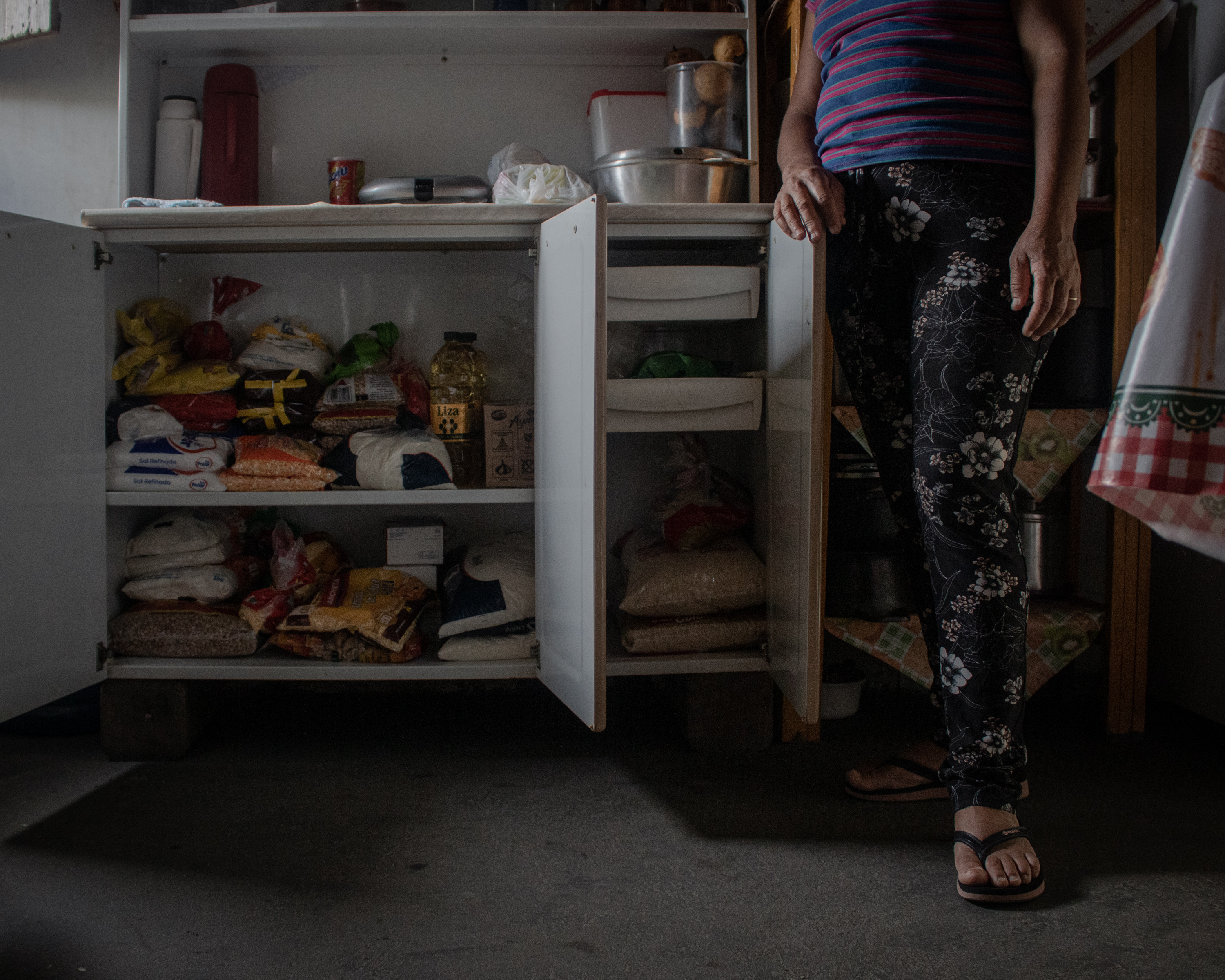 A photo of Mariele revealing the cupboard that she uses to keep food.