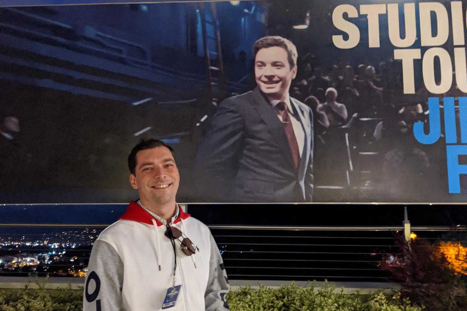 A photo of Igor posing in front of a poster of Jimmy Fallon.