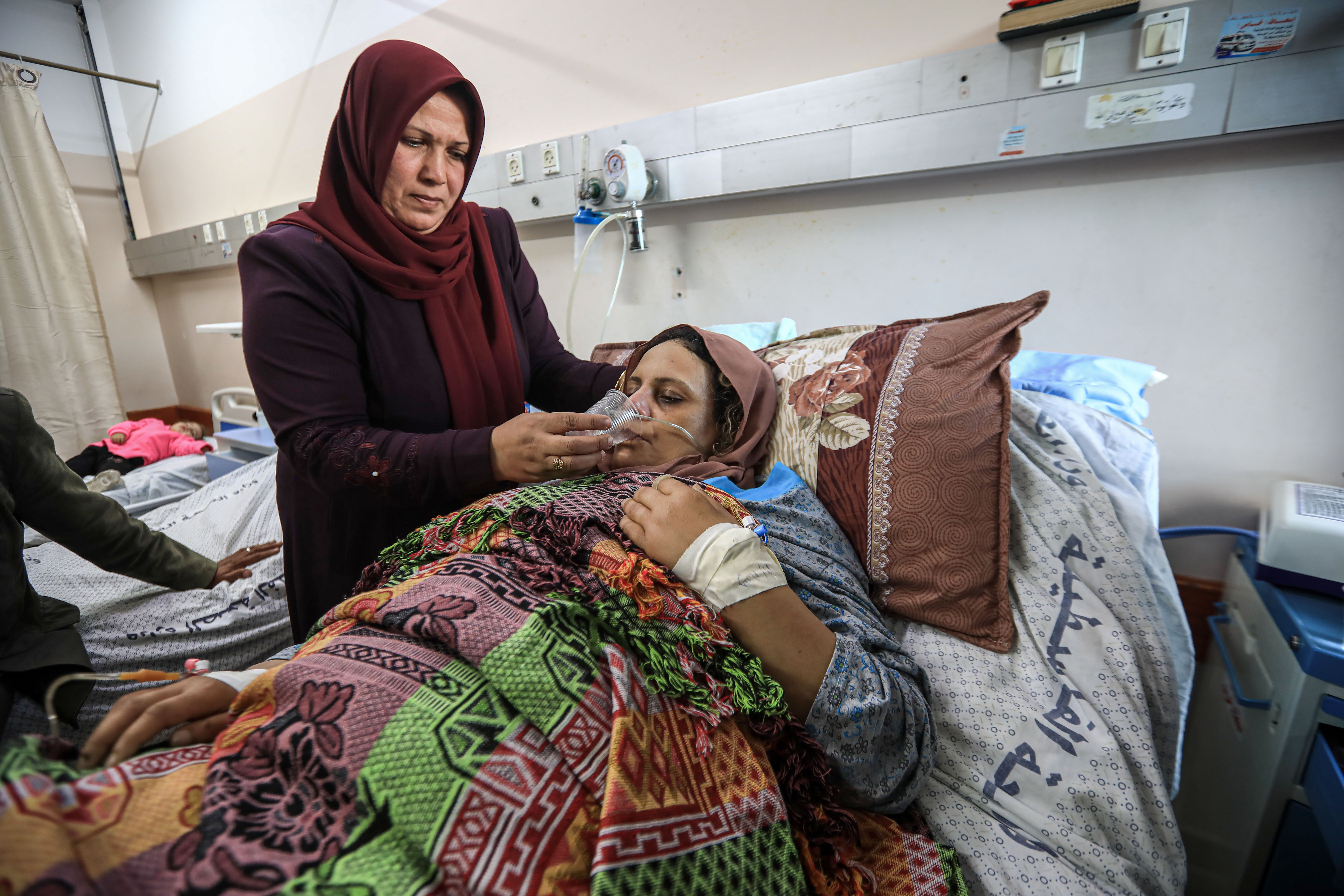 A woman helps her sister to drink water