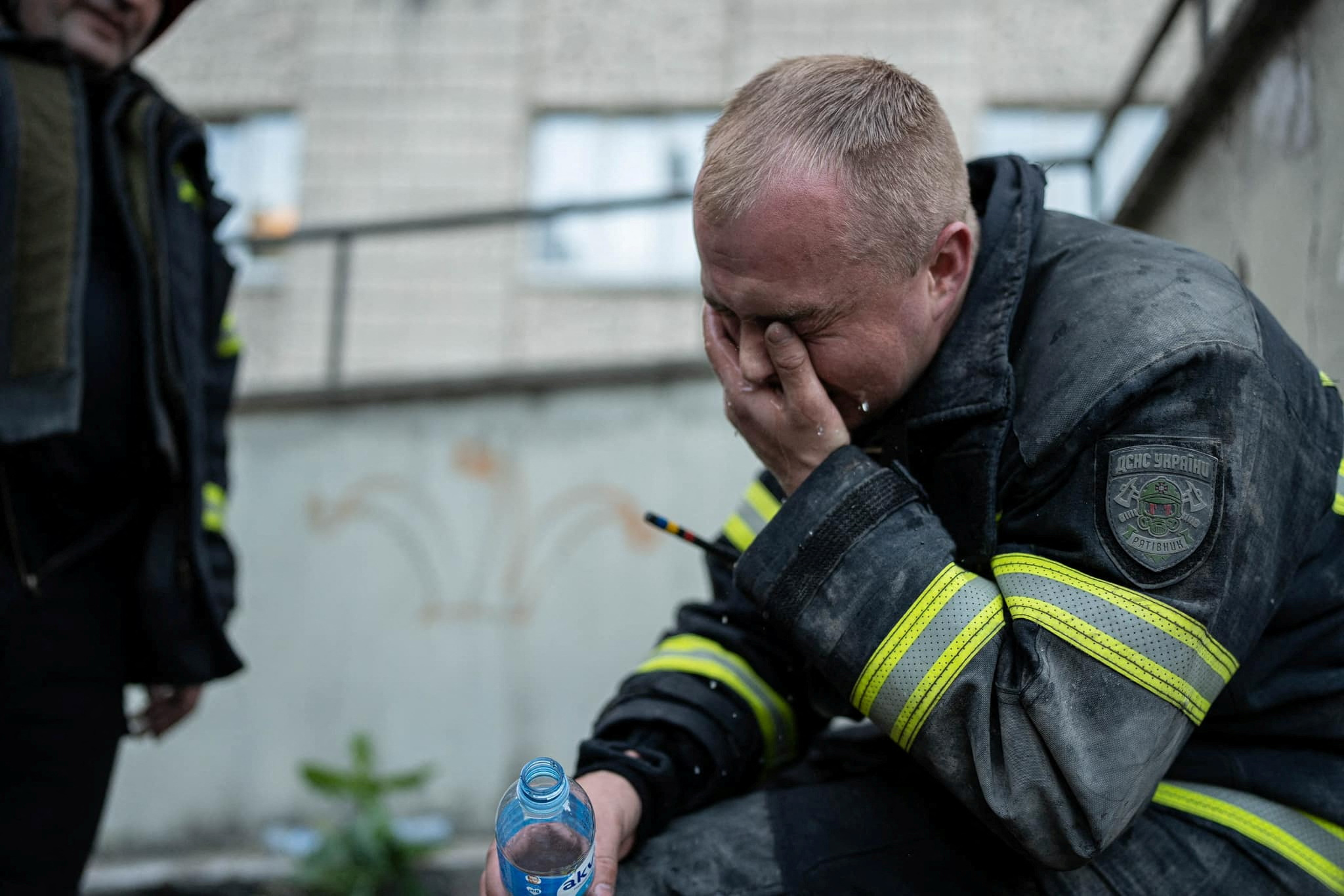 A rescuer reacts at the area where an apartment building has been damaged