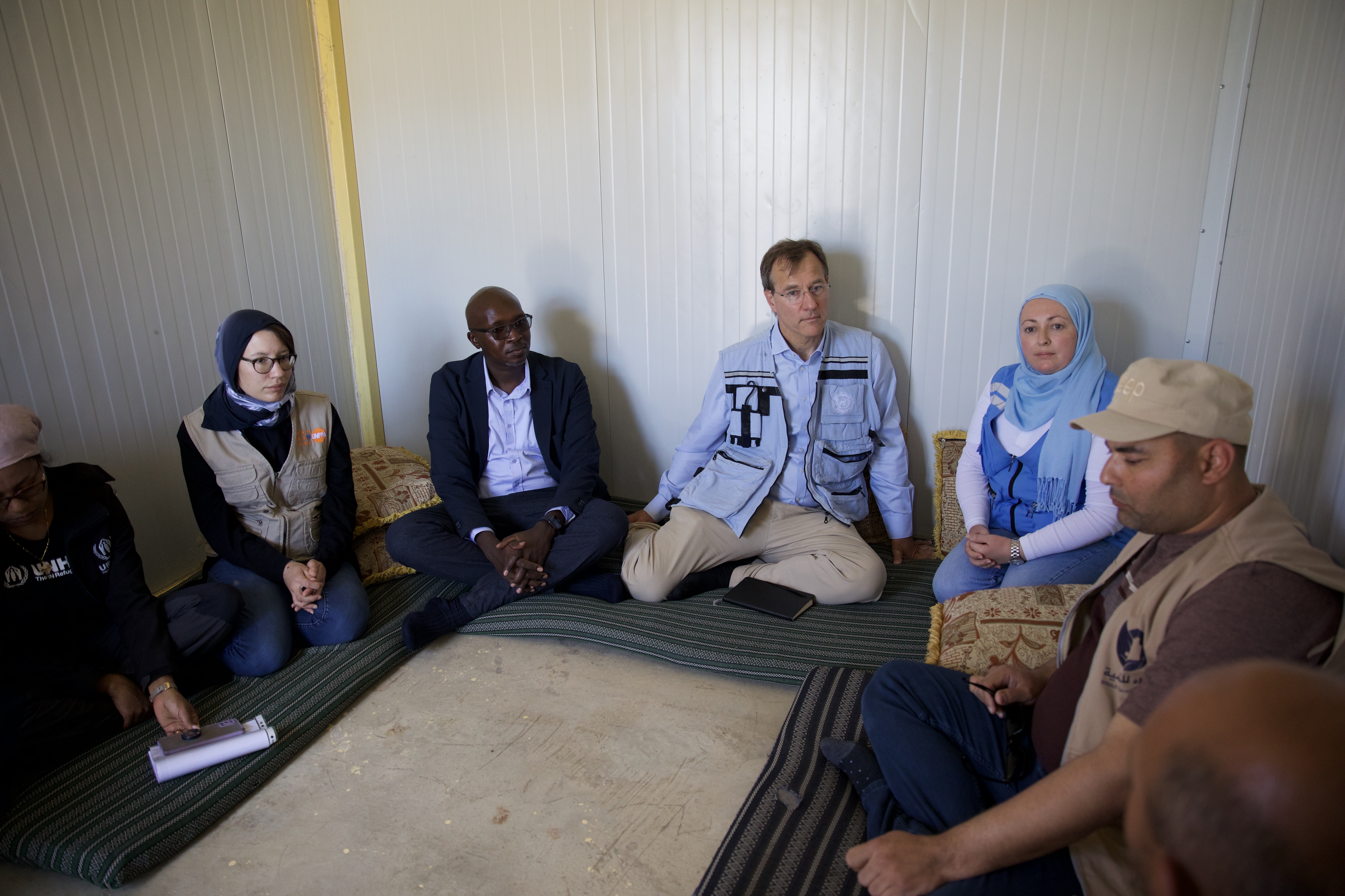 A group of people sit on the floor in discussion