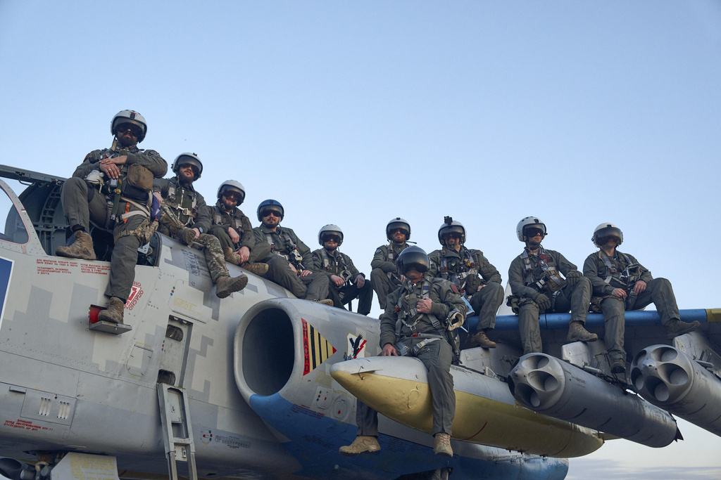 Ukrainian air force pilots pose for a photo as they sit on a Su-25 ground attack jet on their base in Eastern Ukraine, Thursday, May 4, 2023. (AP Photo/Libkos)