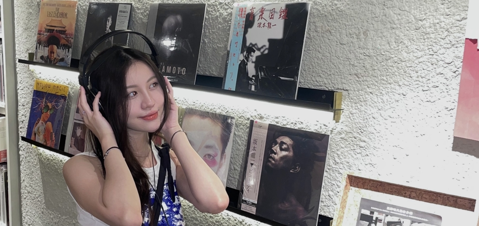 Aurelia VIzal, an ethnic Chinese Indonesian. She's listening to music and has her hands over her earphones. She looks happy and relaxed.