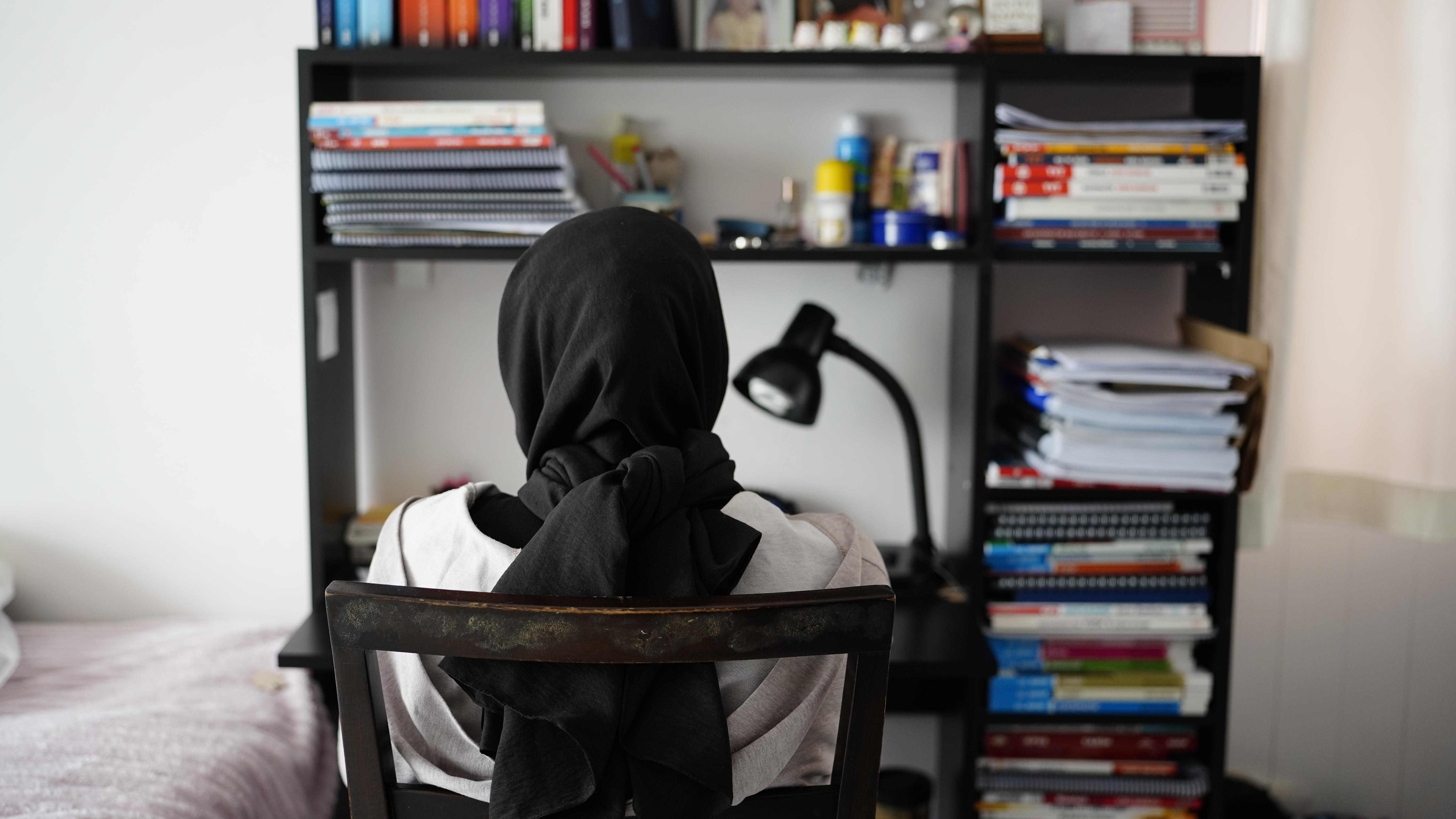 Bediha studies at her desk, surrounded by books