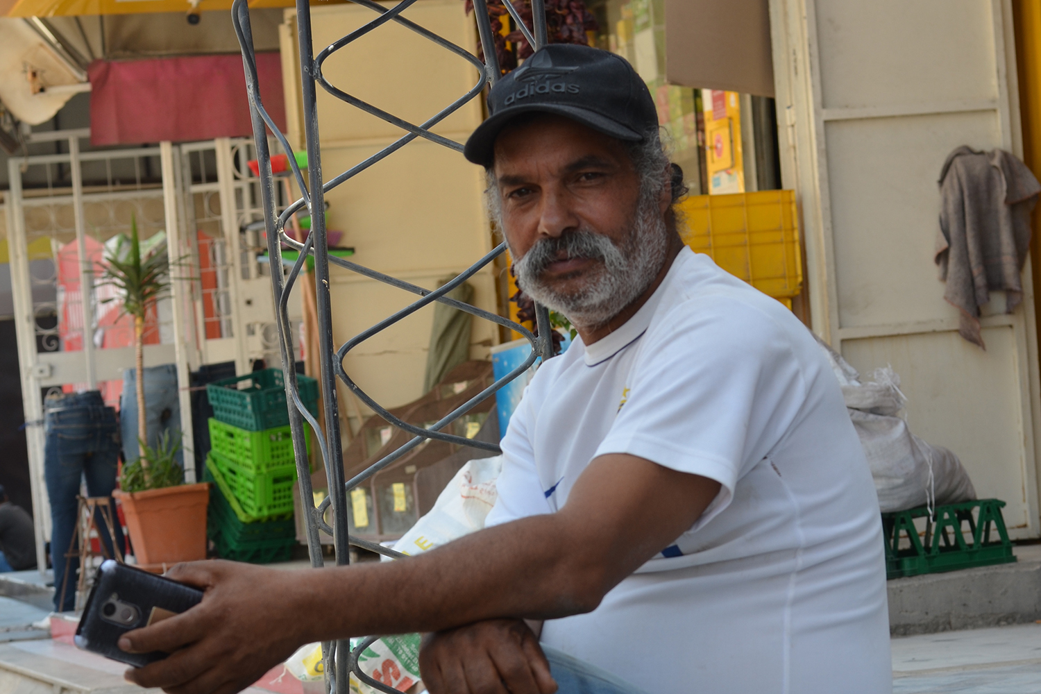Chokri Ben Fradj, in a black cap, gestures as he speaks