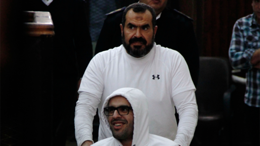 Mohamed Soltan, a dual U.S.-Egyptian citizen, is pushed by his father Salah.