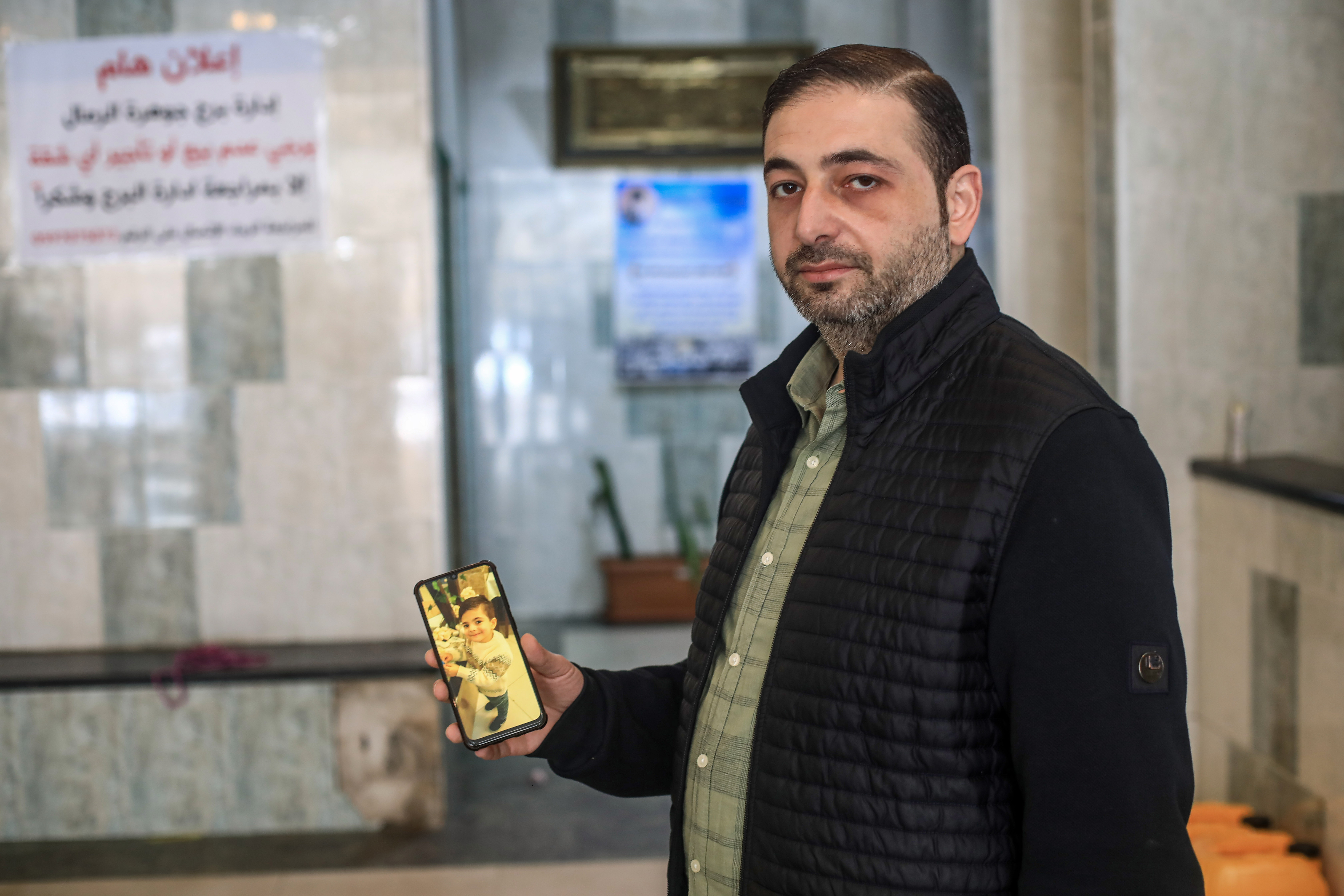 A man holds his son's photo