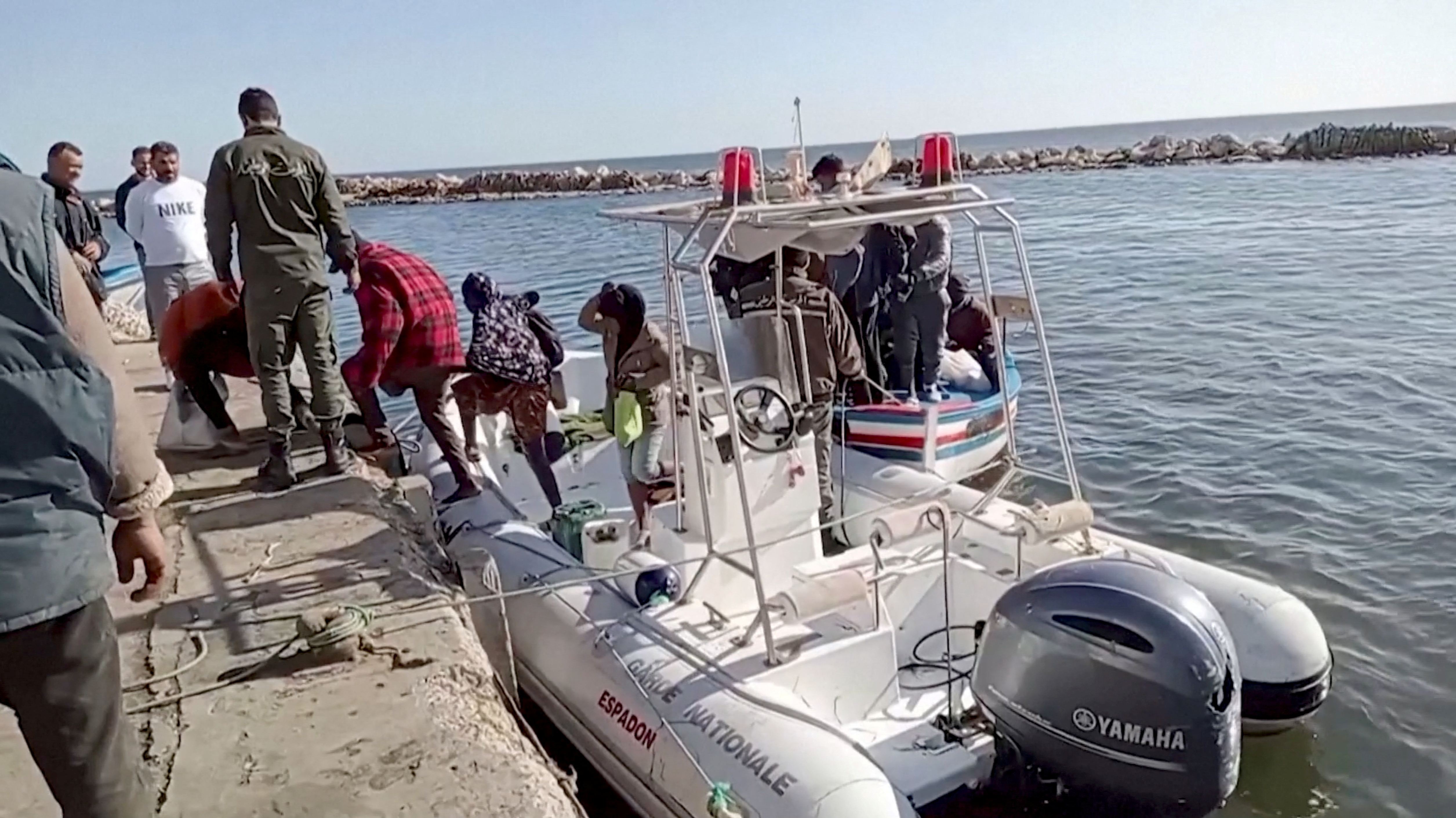 FILE PHOTO: A Tunisian national coast guard helps migrants to get off a rescue boat in Jbeniana, Safx, Tunisia April 23, 2022, in this screen grab taken from a handout video taken April 23, 2022. Wahid Dahech/ Handout via REUTERS THIS IMAGE HAS BEEN SUPPLIED BY A THIRD PARTY. MANDATORY CREDIT./File Photo