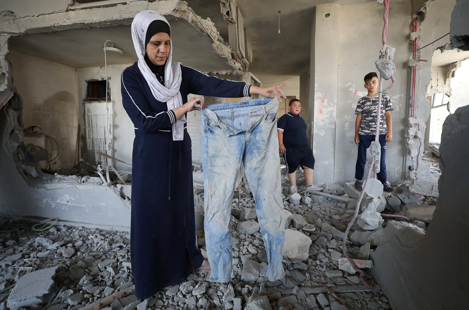 Tamara holds up a pair of jeans forgotten in the home and now wrecked