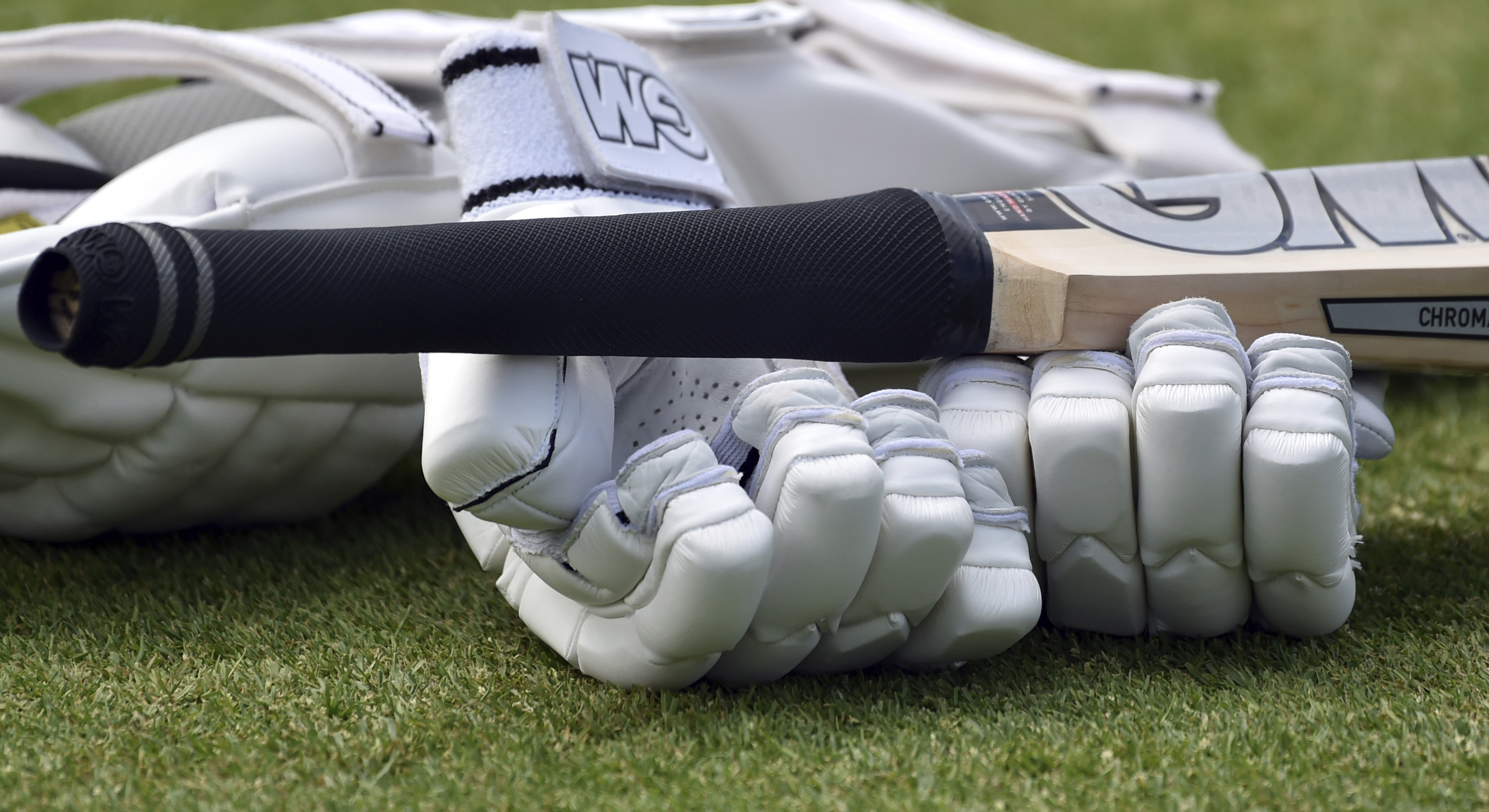 A close up view of cricket gloves and bat