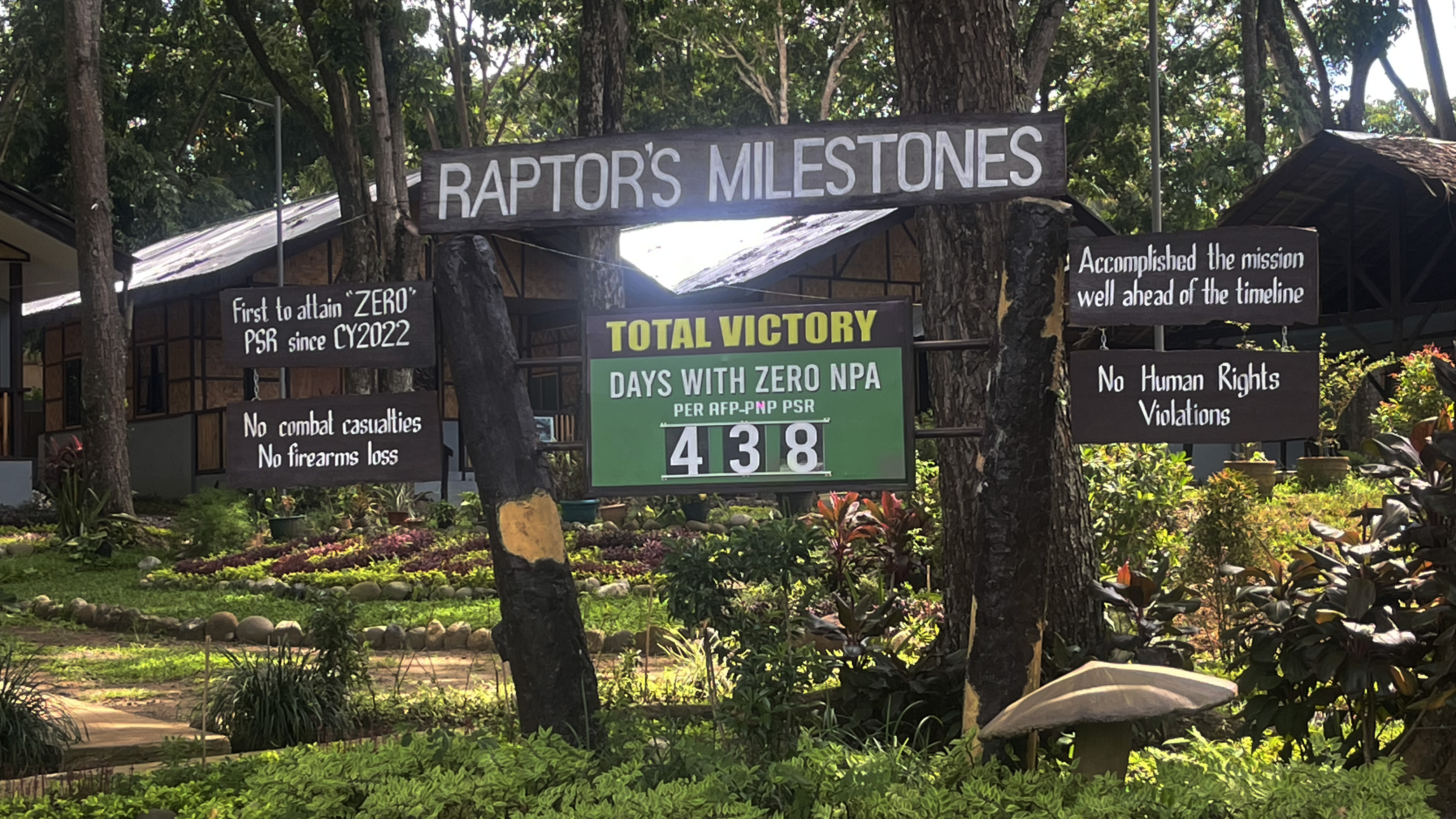 The military base in Davao. Placards hammered to the trees lay out the 'Raptor's Milestones' including no combat casualties. no human rights violations and no firearms losses.
