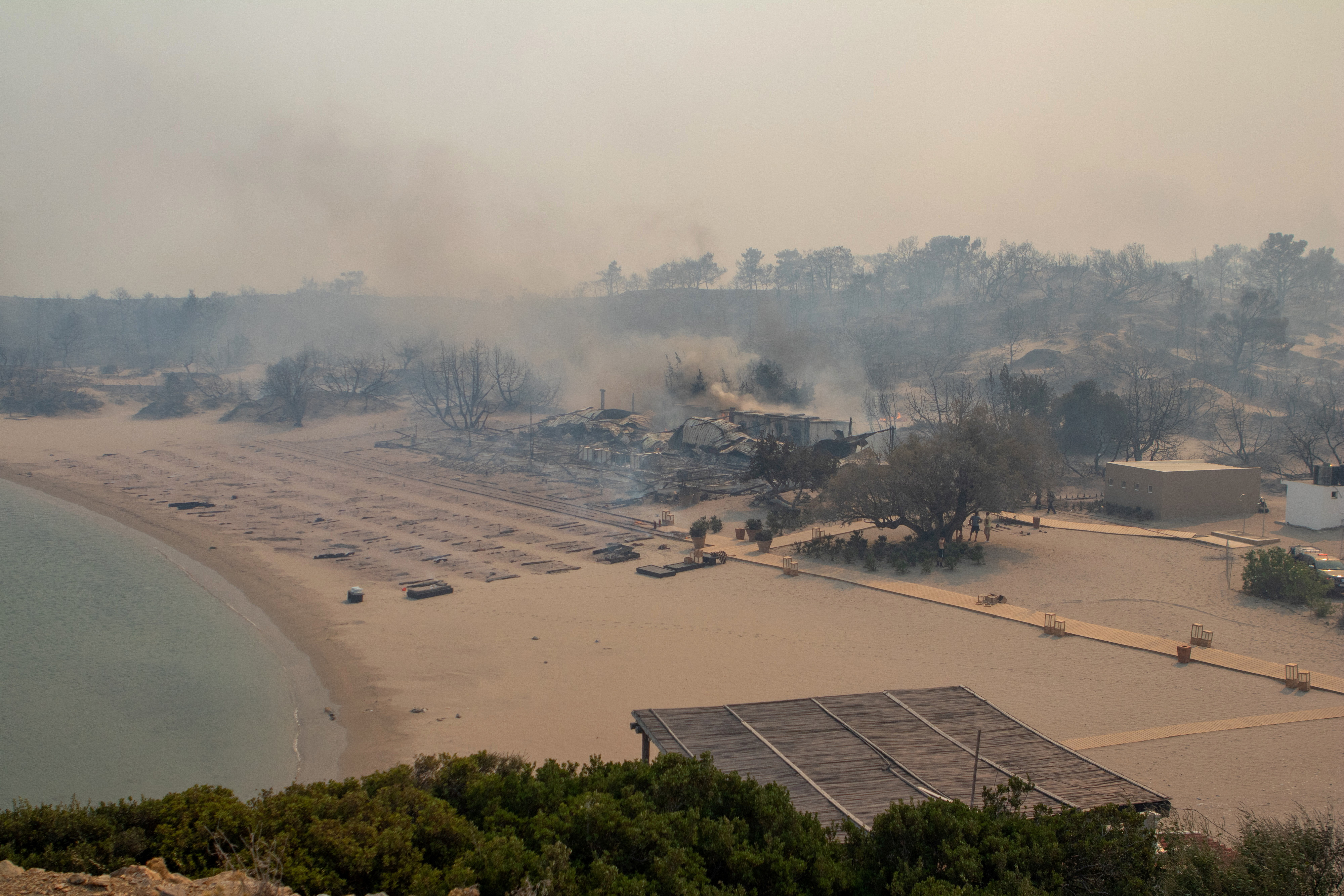 A wildfire burns next to a beach near Lindos,