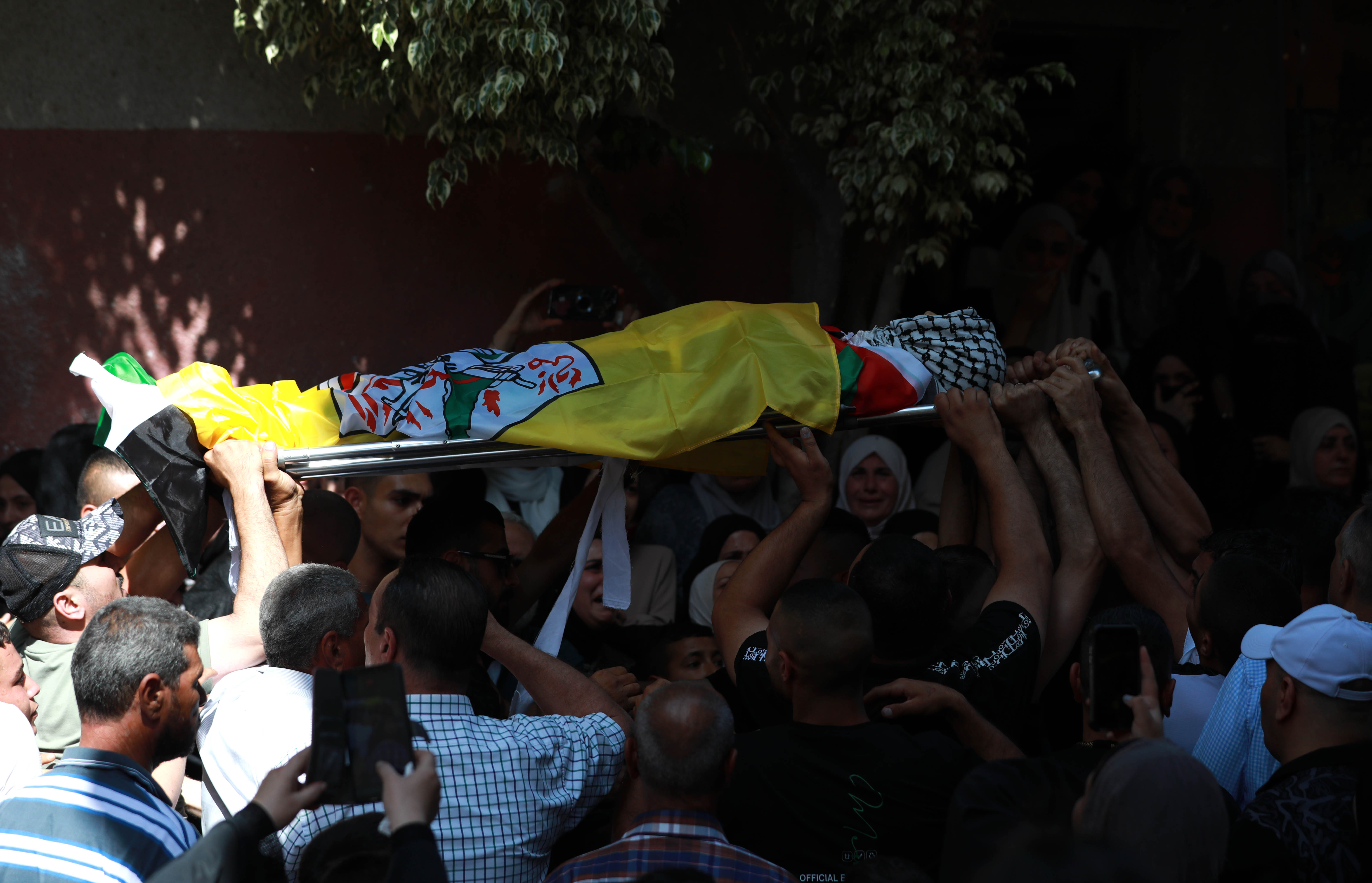 The body of Faris Abu Samra is carried during his funeral procession