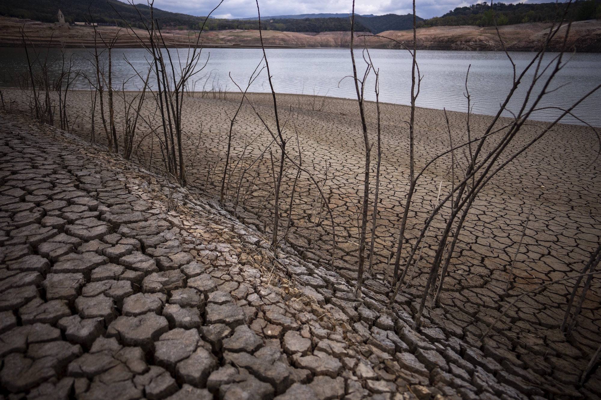 The dry cracked earth is visible near the Sau reservoir, north of Barcelona, Spain, Tuesday, April 18, 2023.