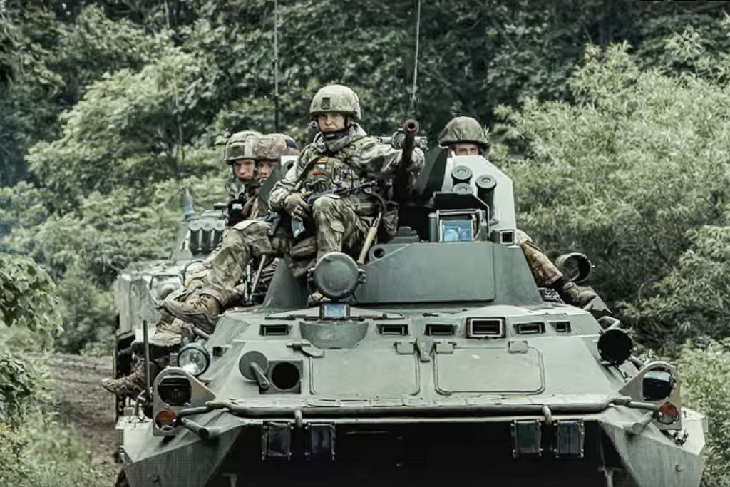 In this photo taken from video released by the Russian Defense Ministry Press Service on Wednesday, July 12, 2023, Russian ride a military vehicle at an undisclosed location. (Russian Defense Ministry Press Service via AP)