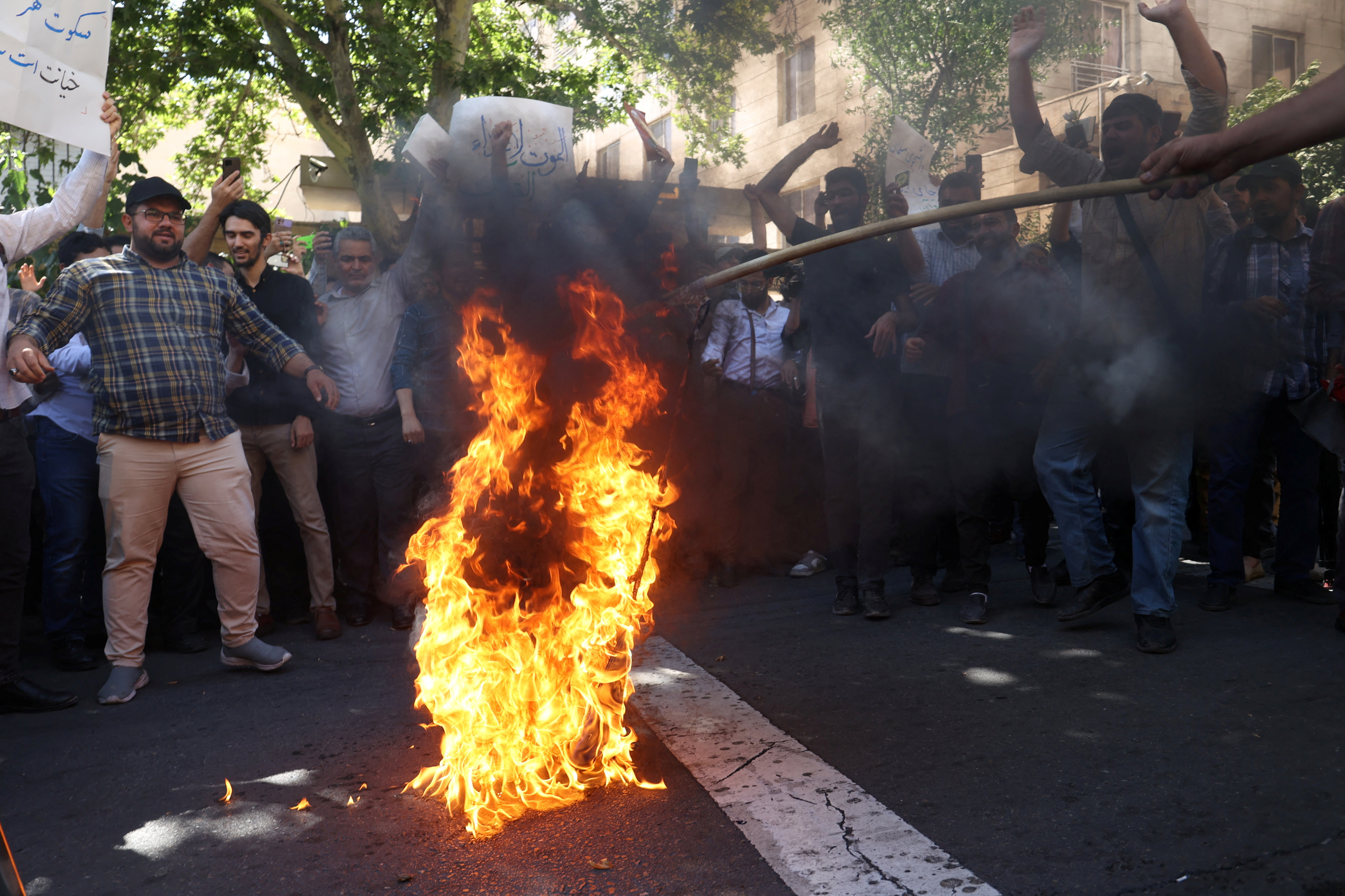 Demonstrators burn the Swedish flag during a protest in front of the Swedish embassy in Tehran against a man who burned a Quran in Stockholm