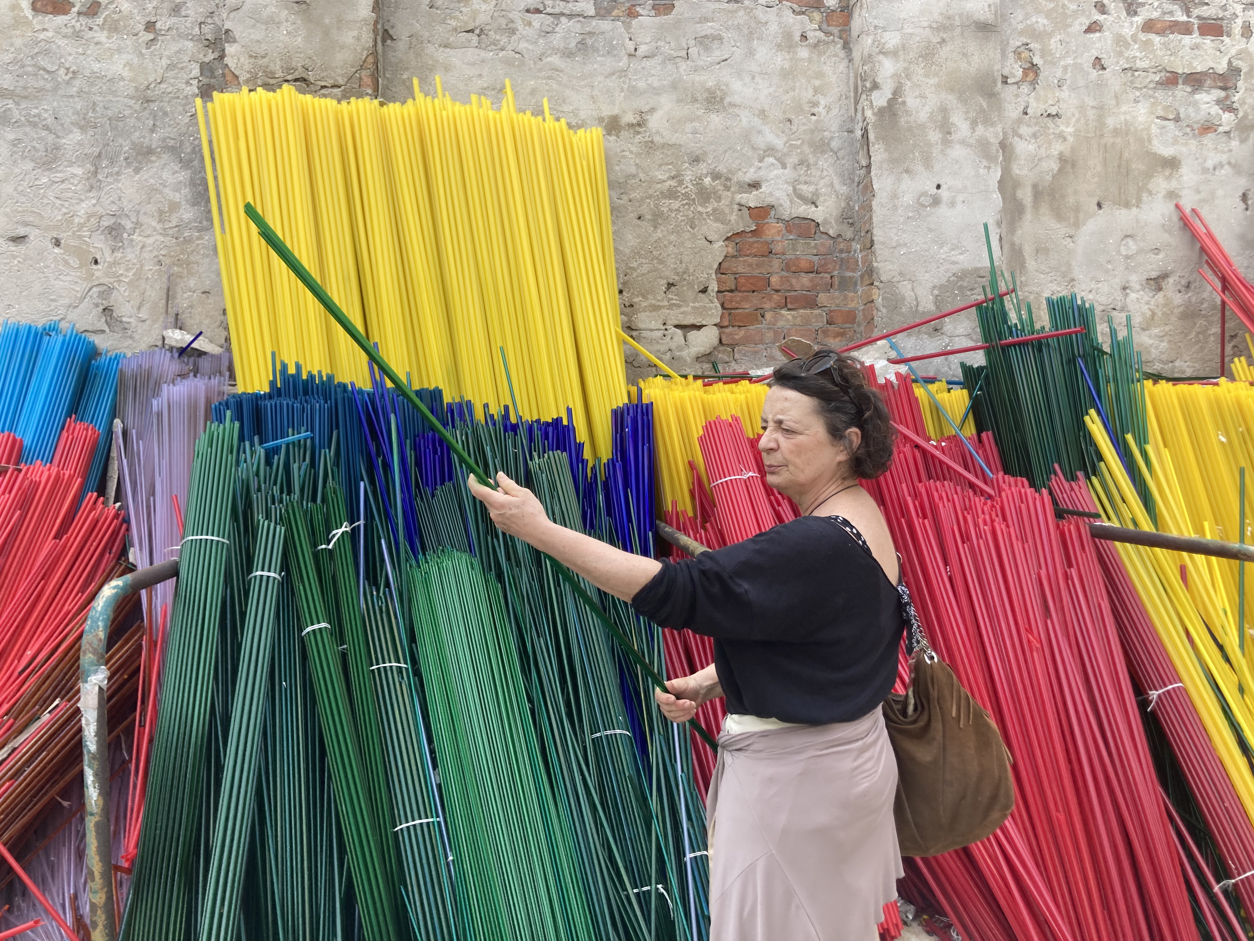 Lucia examines coloured glass rods that she buys to turn into objects like chalices and thimbles