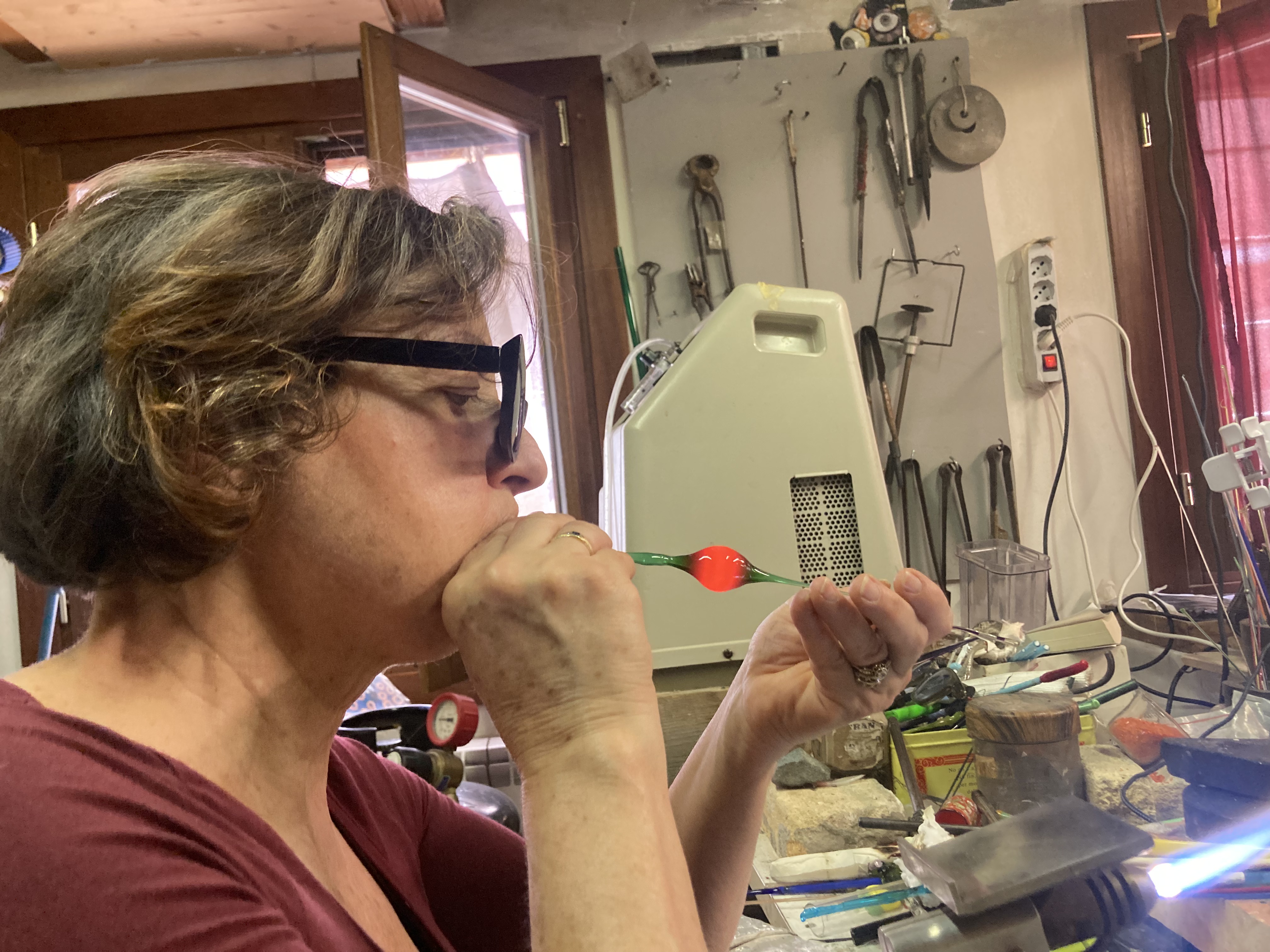 Lucia blows molten glass in her atelier