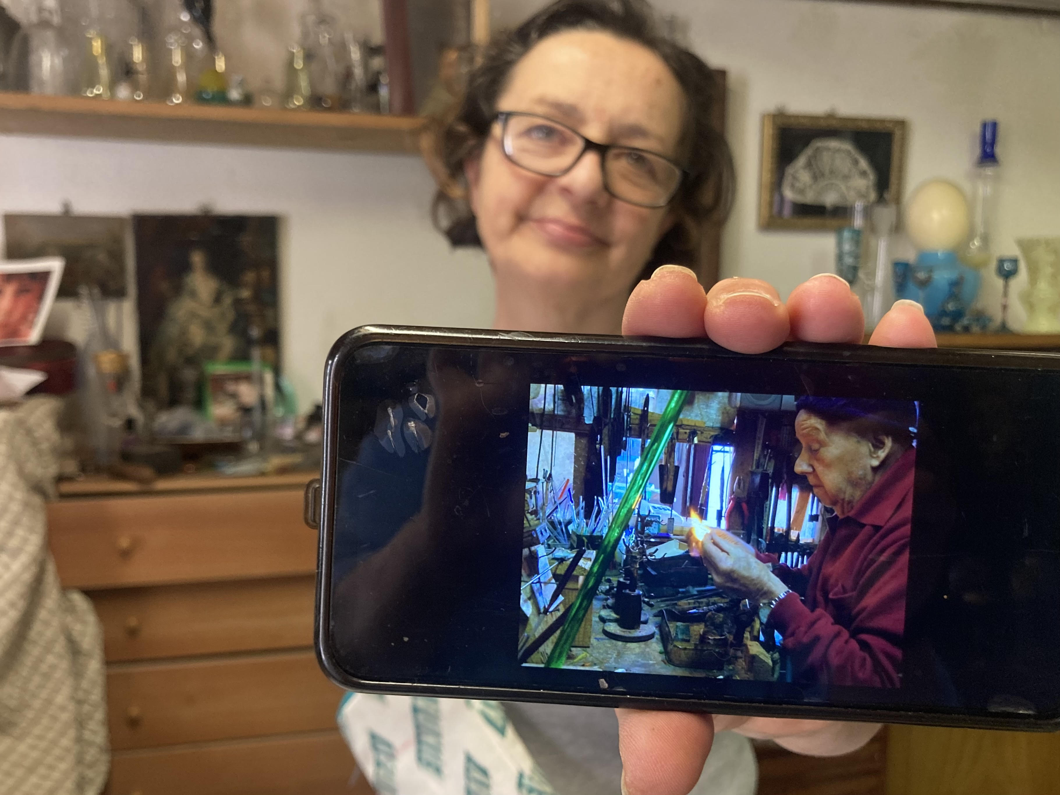 Lucia shows a photo of her father, Marco Santini, blowing glass in his 90s