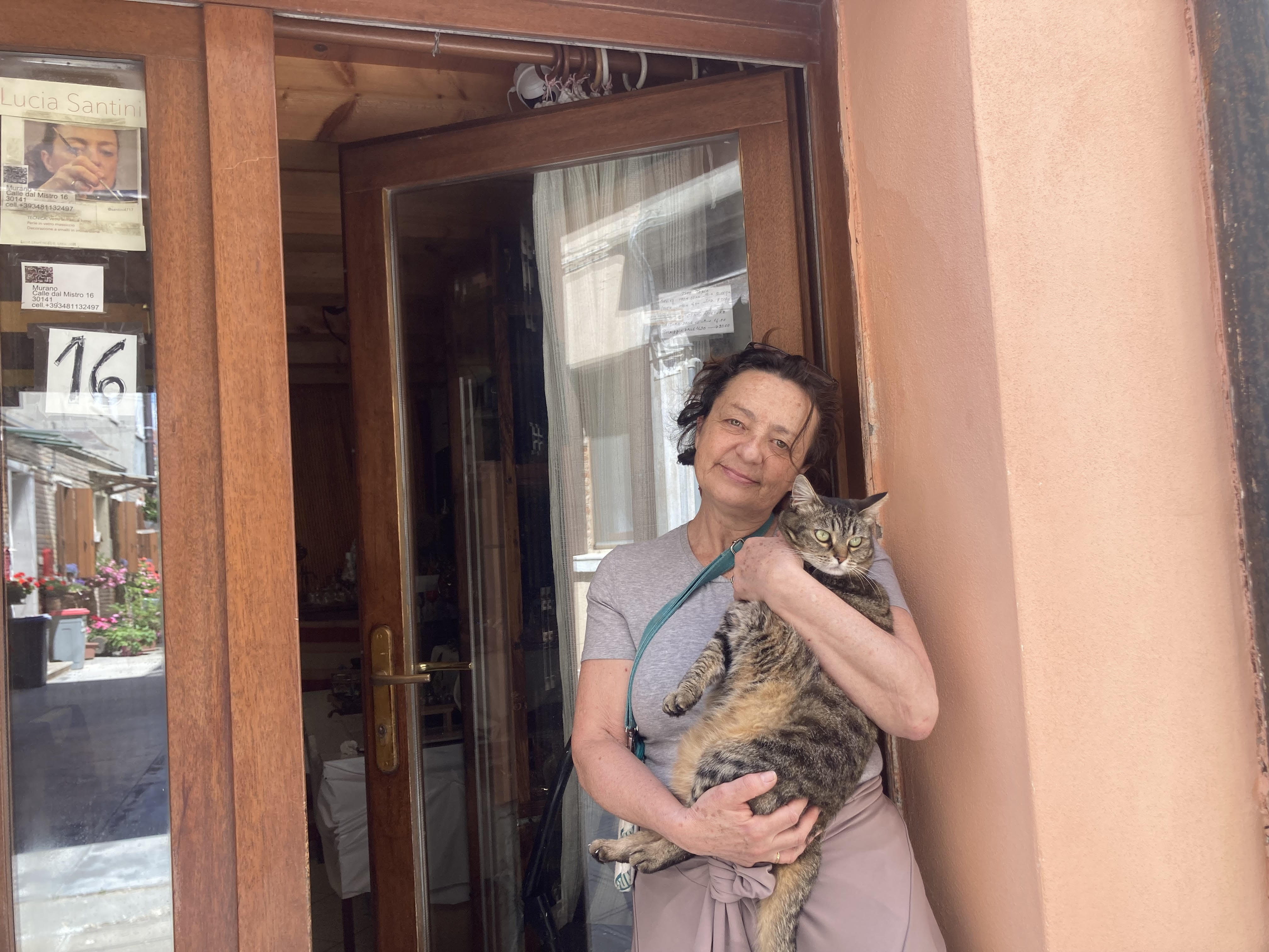 Lucia holds Bella in front of her store