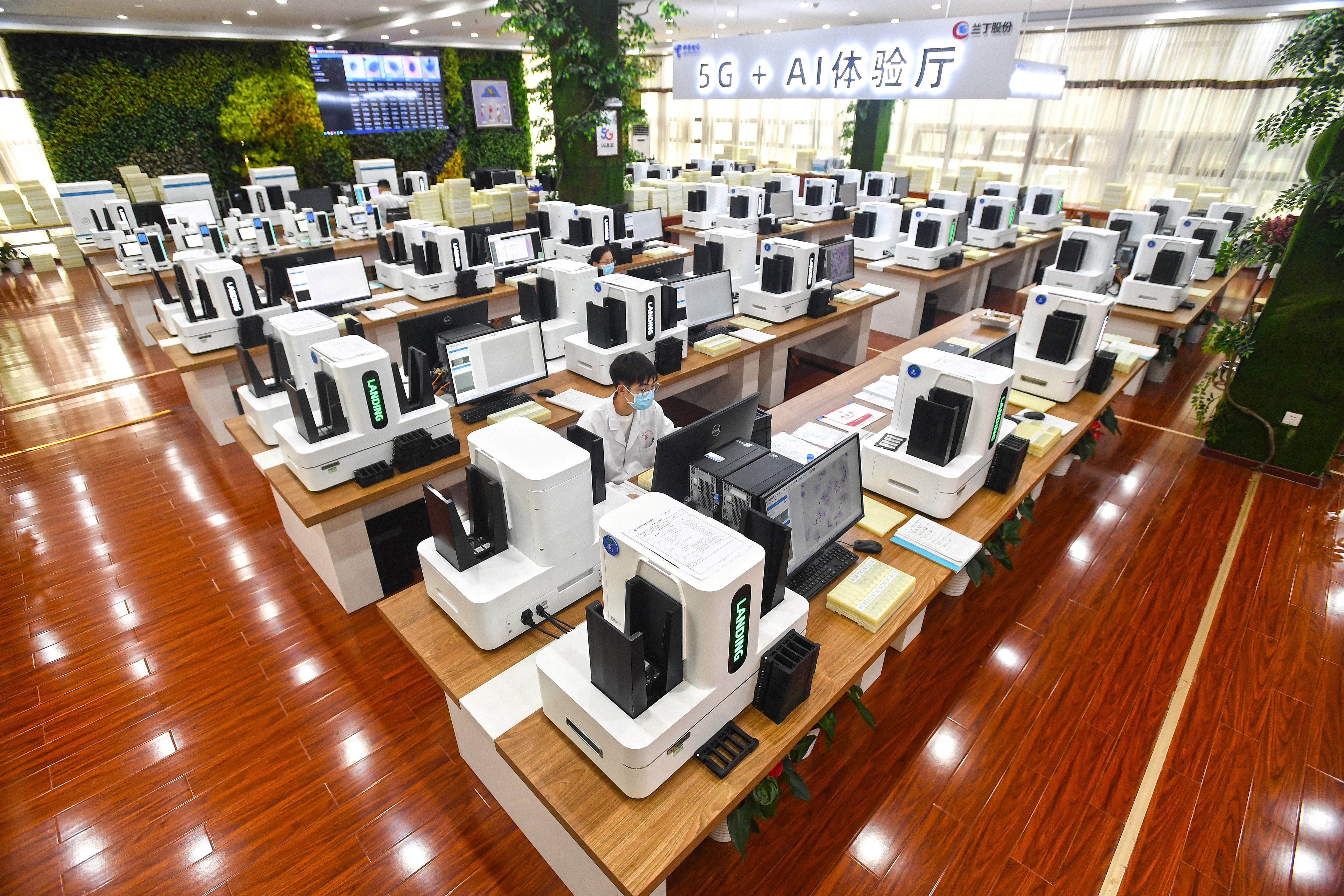 This photo taken on June 15, 2023 shows a laboratory technician conducting artificial intelligence (AI)-based cervical cancer screening at a test facility in Wuhan, in China's central Hubei province. (Photo by STR / AFP) / China OUT / CHINA OUT
