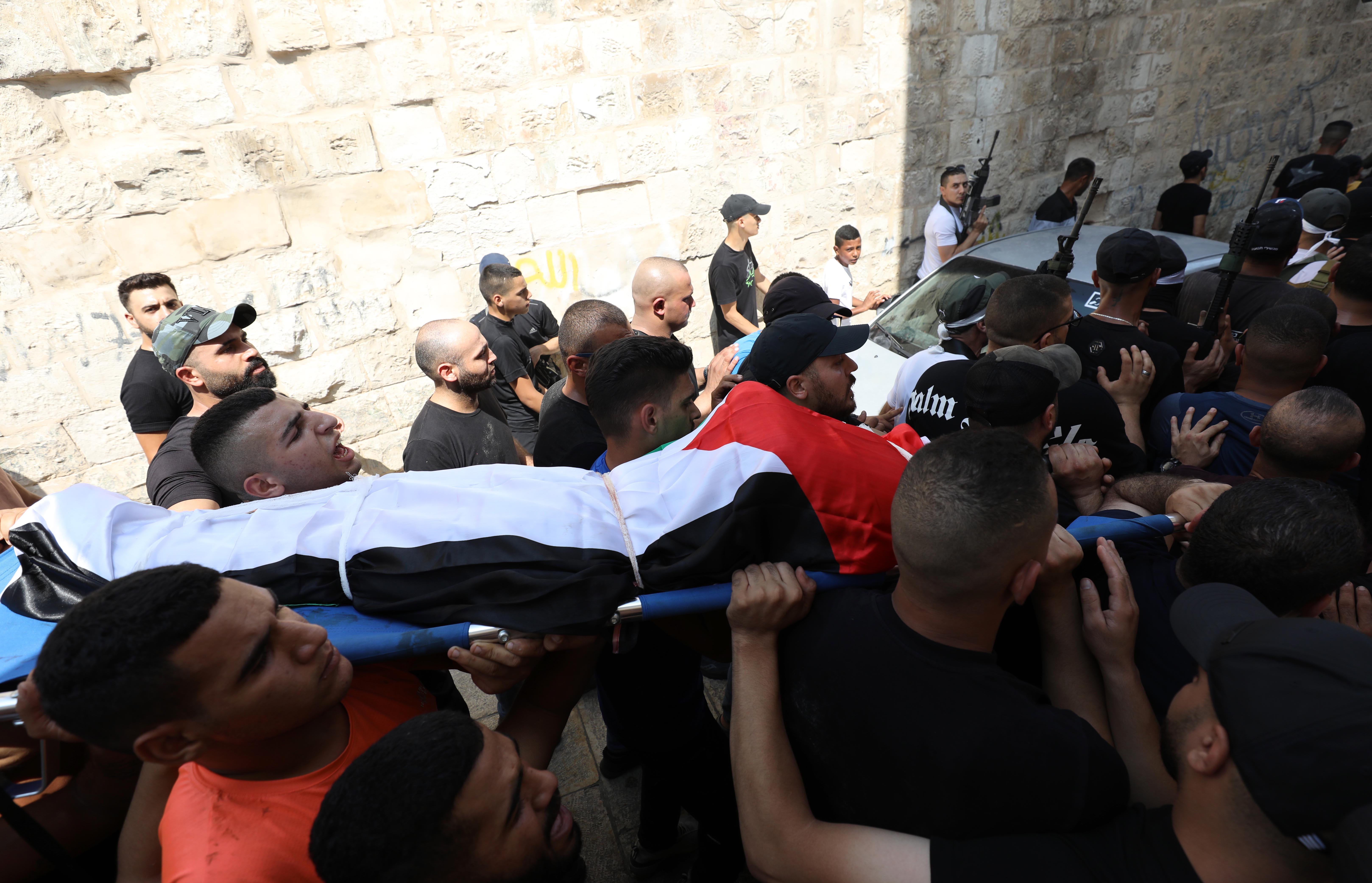 Palestinians carry the body of Mustafa al-Kastoni, wrapped in a Palestine flag, in Jenin on August 17 2023