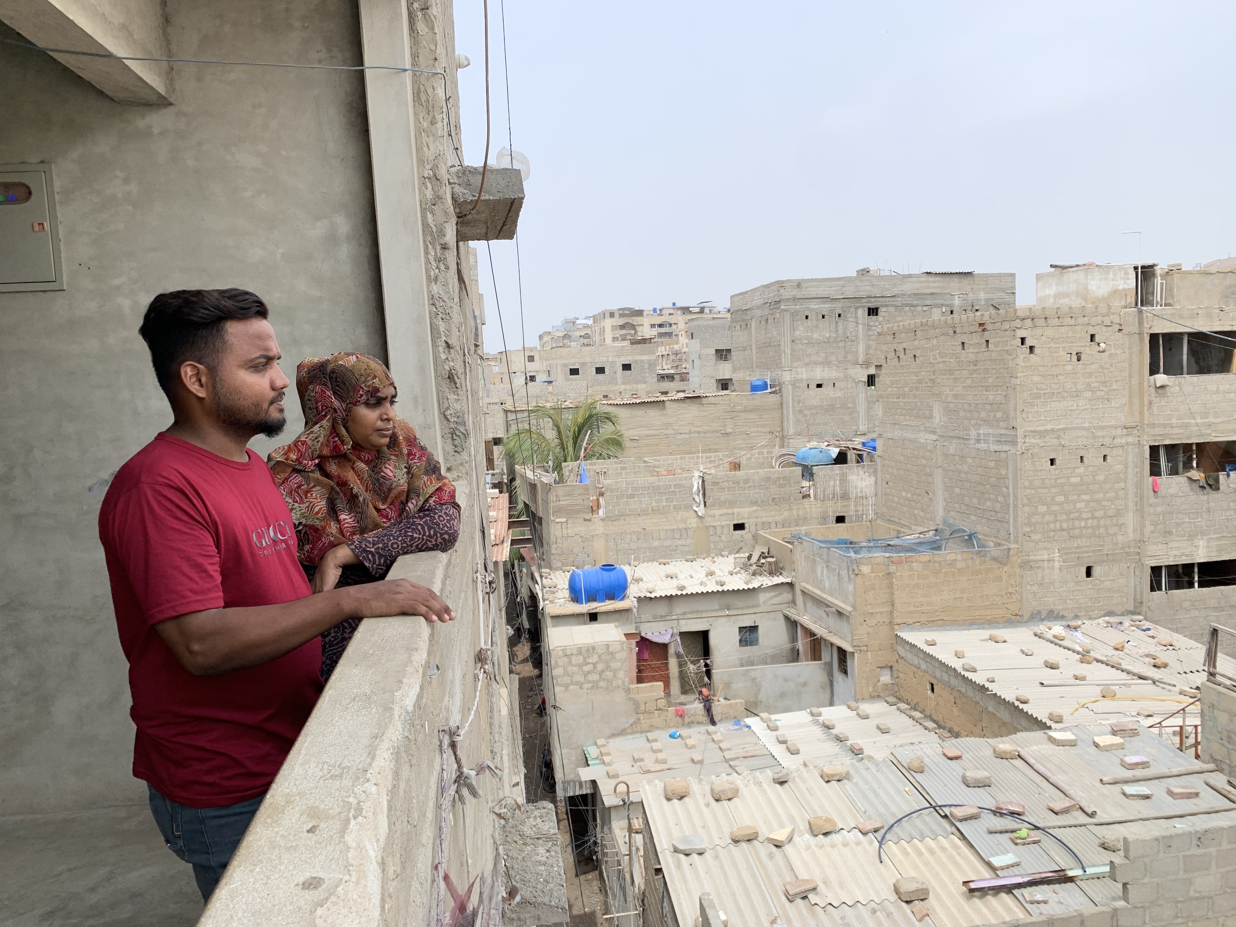A photo of Aisha and Faisal standing on a balcony.