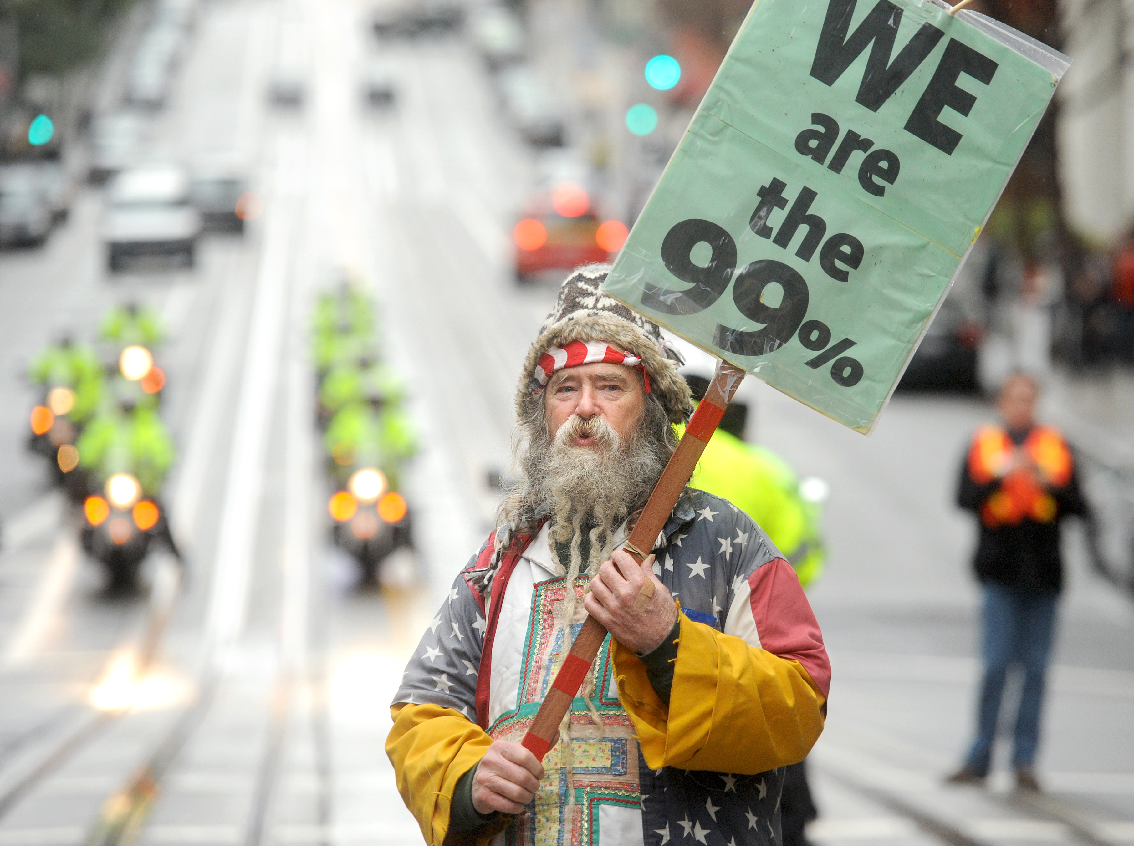 An Occupy protester, who declined to give his name, pickets outside a Bank of America branch on Friday, Jan. 20, 2012, in San Francisco. Anti-Wall Street demonstrators across the U.S. planned rallies Friday in front of banks and courthouses. (AP Photo/Noah Berger)