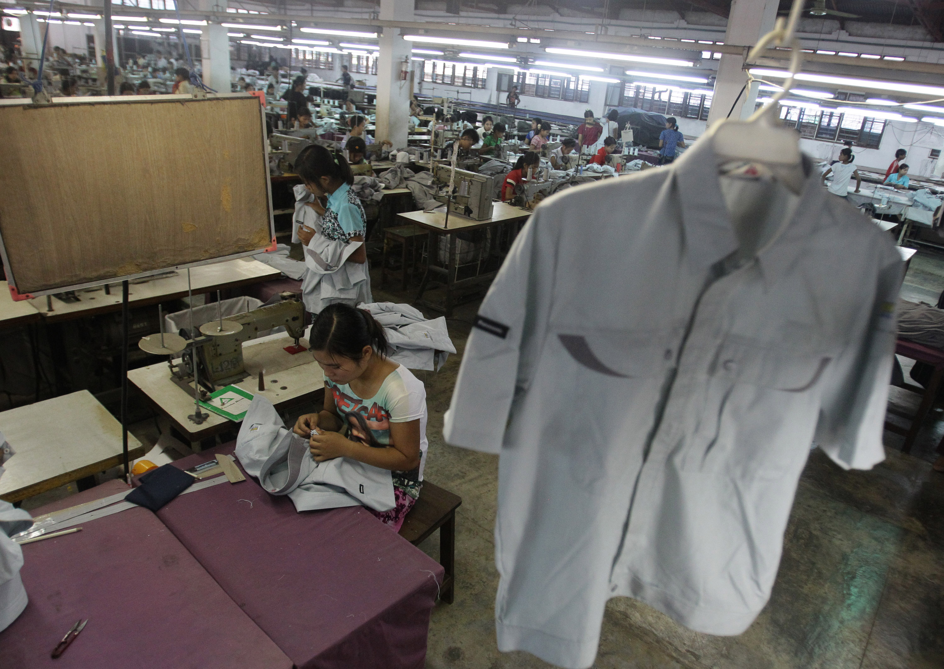 In this photo taken Saturday, April 21, 2012, a young worker sews a shirt at a garment factory in Yangon, Myanmar.