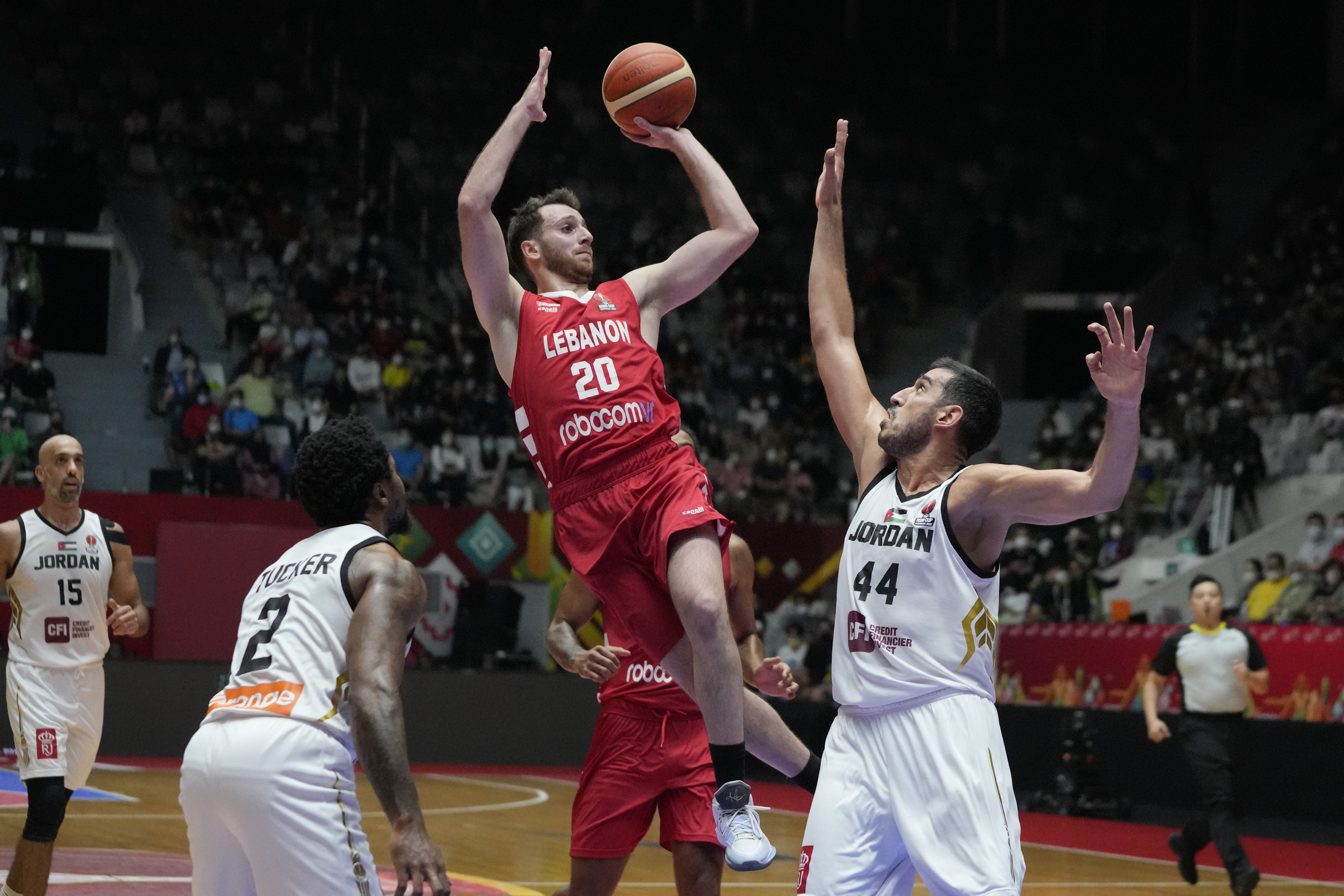 Lebanon's Wael Arakji, center, shoots over Jordan's Ahmad Al Dwairi, right, and Dar Tucker