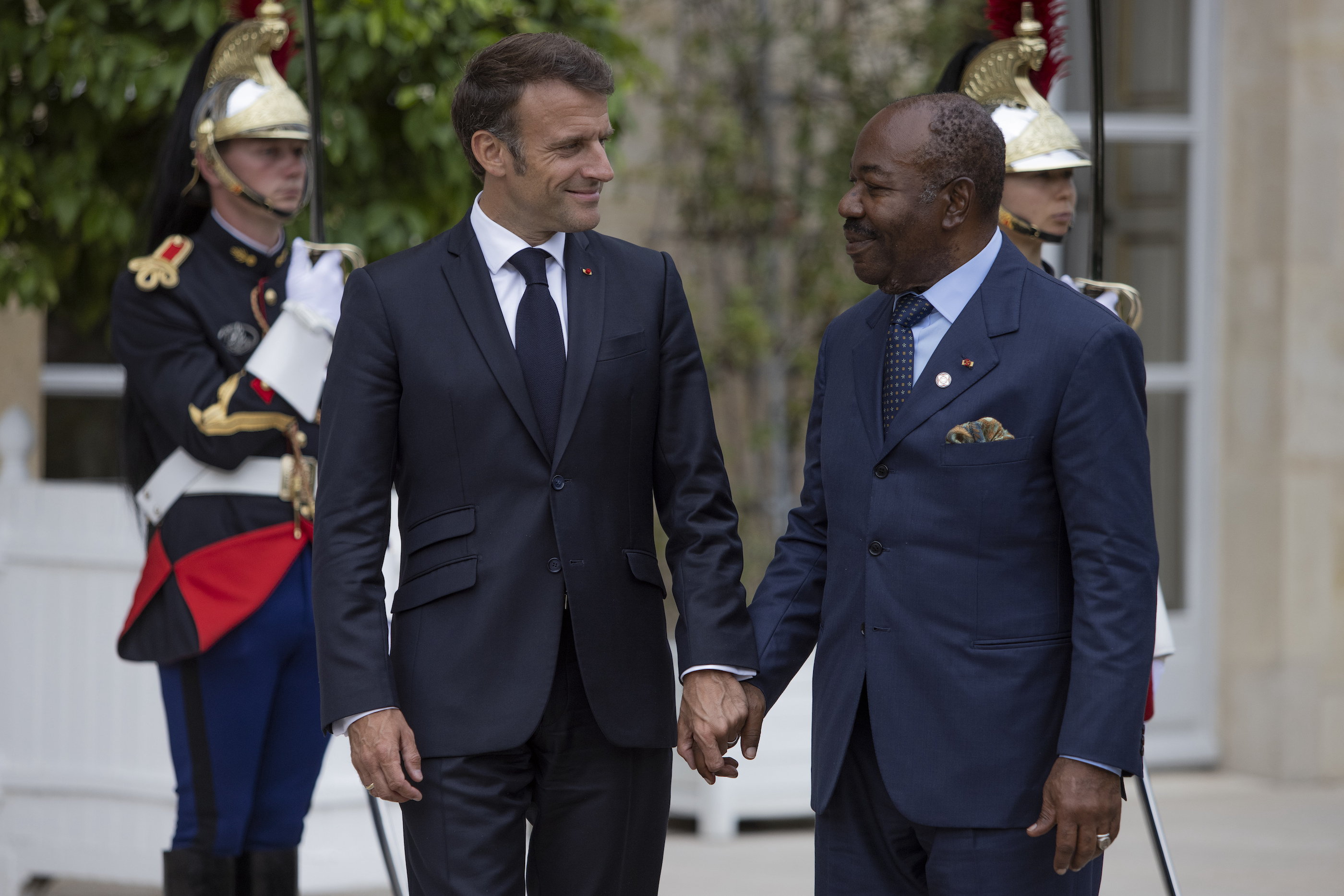 French President Emmanuel Macron, left, holds the hand of President of Gabon Ali Bongo at the Elysee Palace, Thursday, June 22, 2023 in Paris.