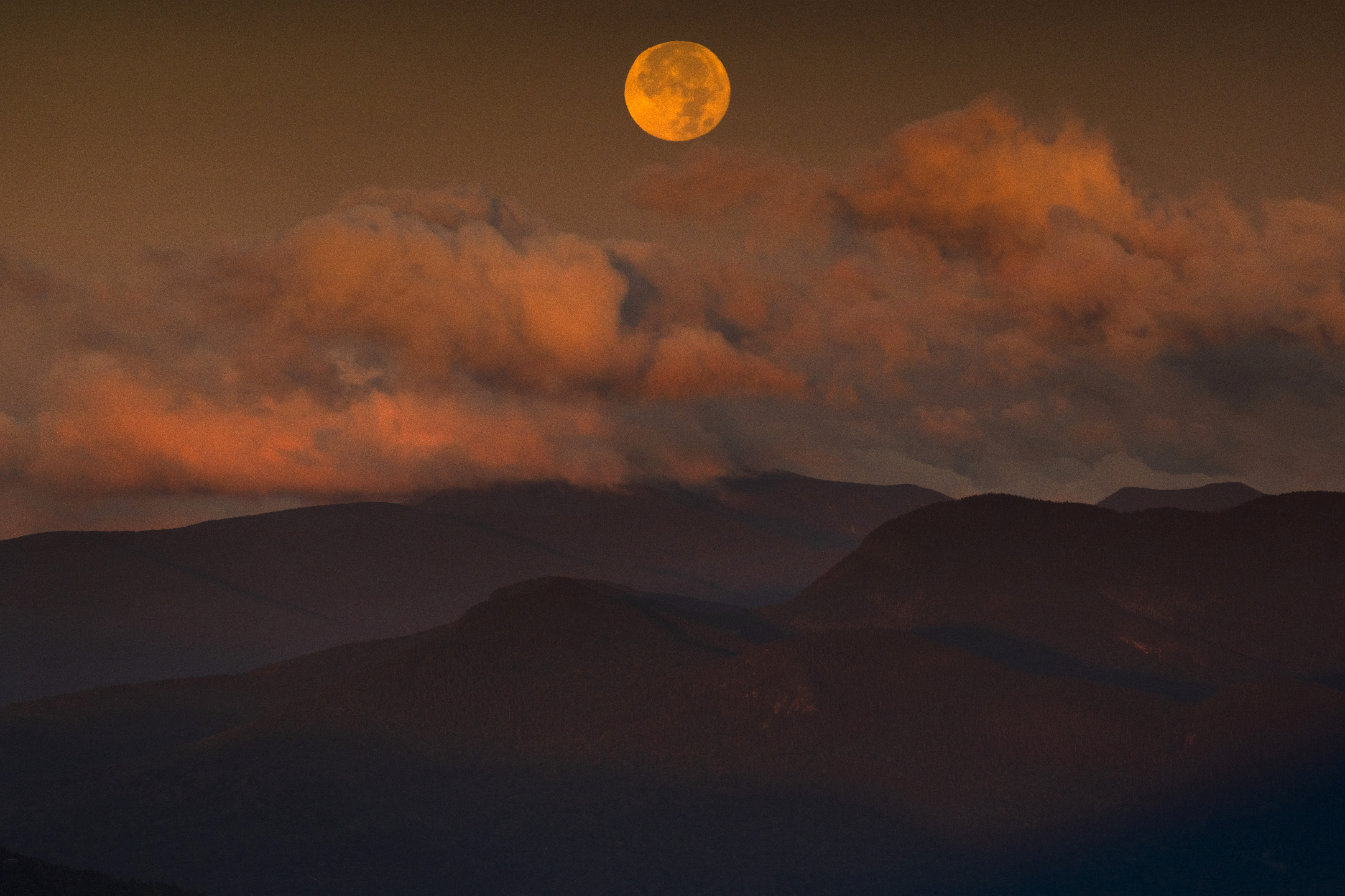 The super blue moon sets over the White Mountain National Forest at sunrise