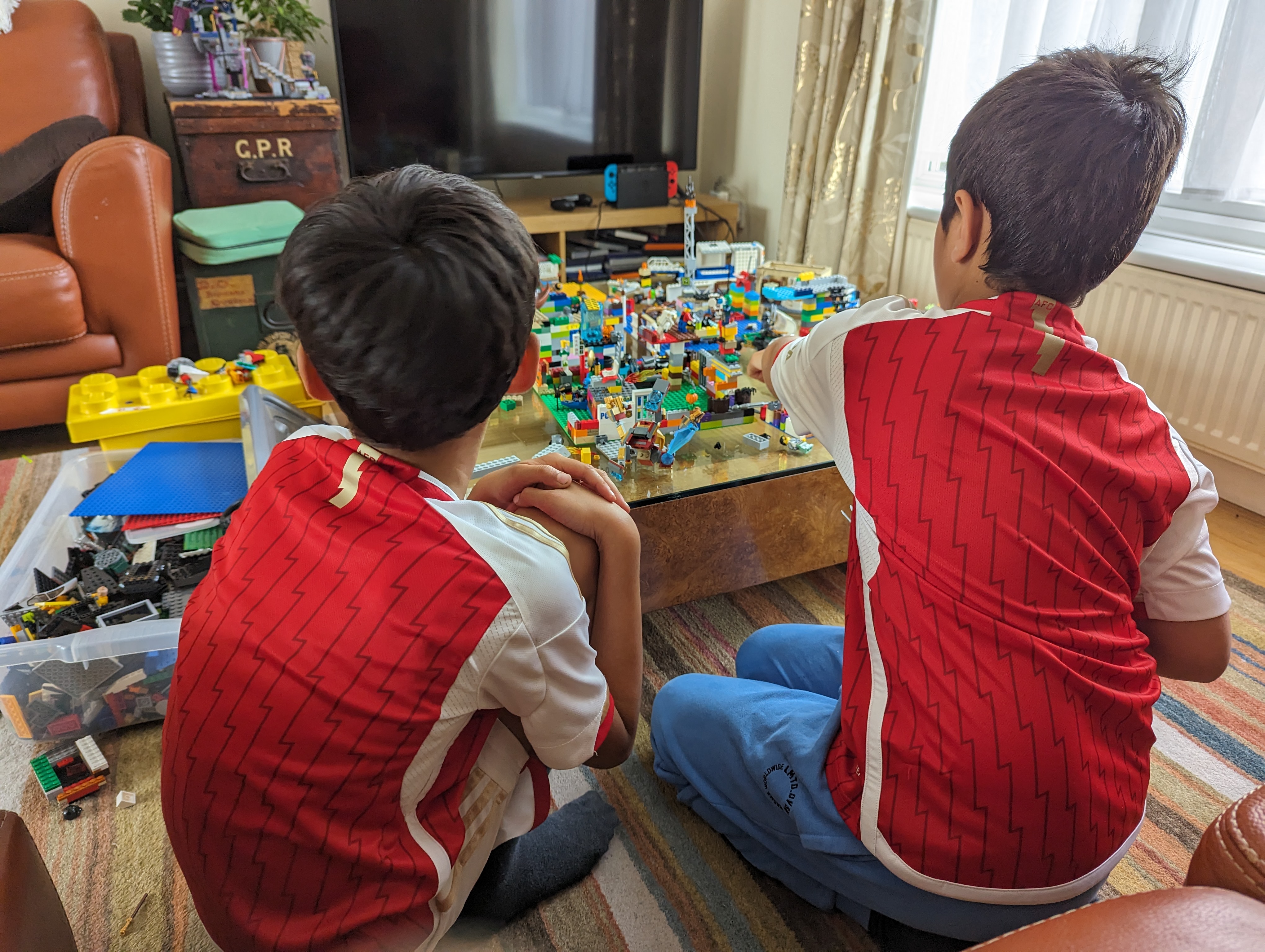 A photo of two children playing with Lego.