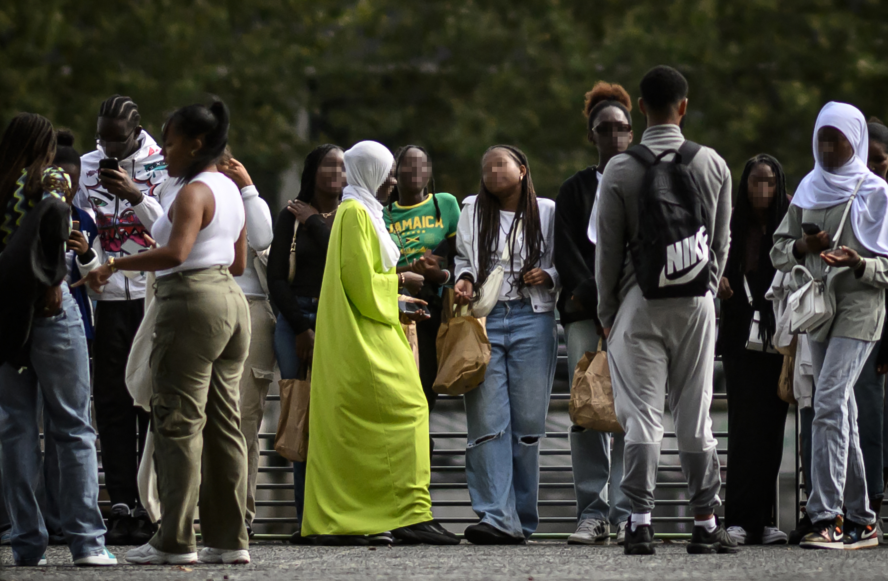 A young woman wearing an Abaya (C) speaks with others on a street in Nantes, western France on August 31, 2023. - The French government's decision to ban schoolgirls wearing abayas -- long, flowing dresses of Middle Eastern origin -- has opened a fresh debate about the country's secular laws and the treatment of Muslim minorities. (Photo by LOIC VENANCE / AFP)