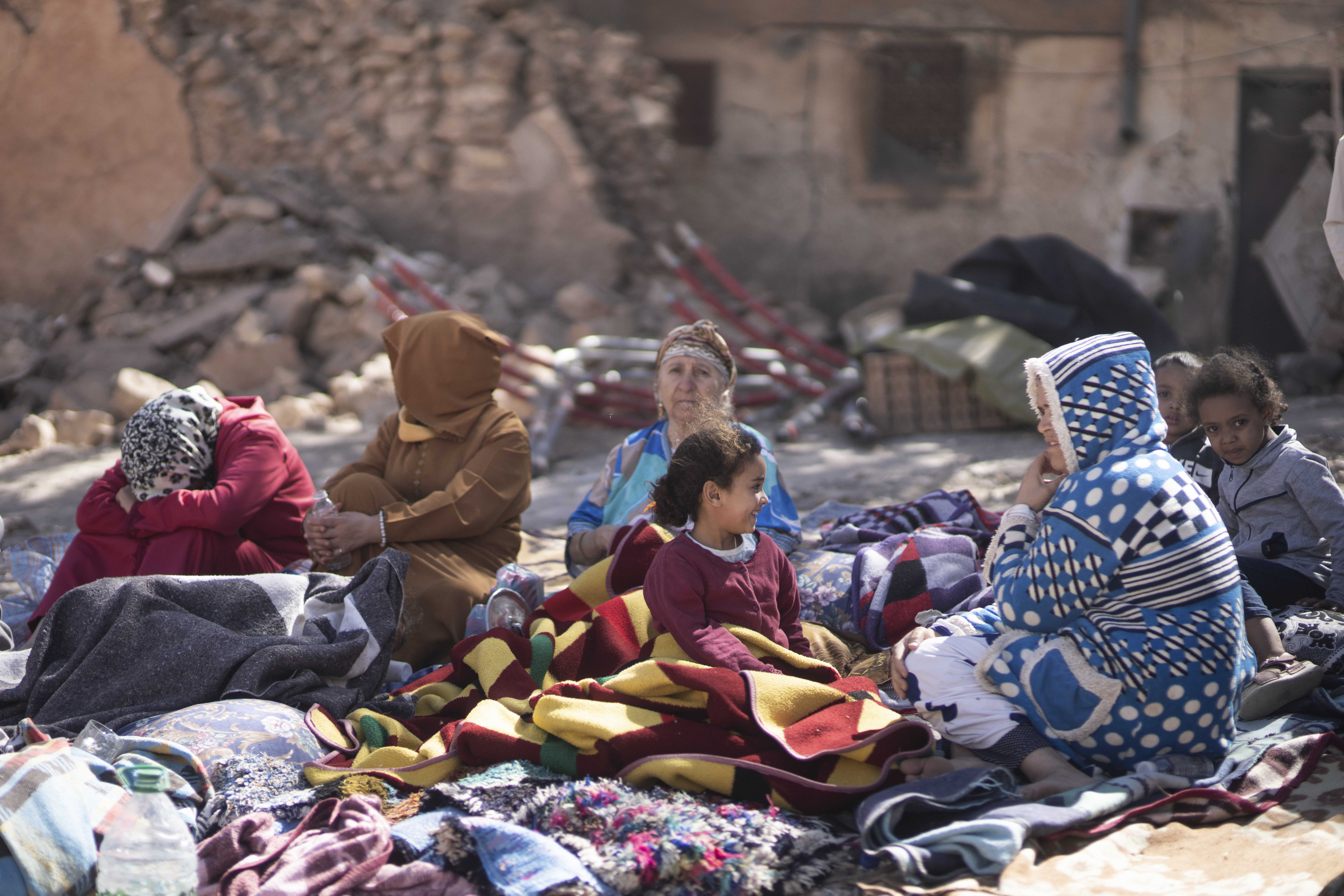 Families sit outside their destroyed homes after an earthquake in Moulay Brahim village, near Marrakech, Morocco, Saturday, Sept. 9, 2023
