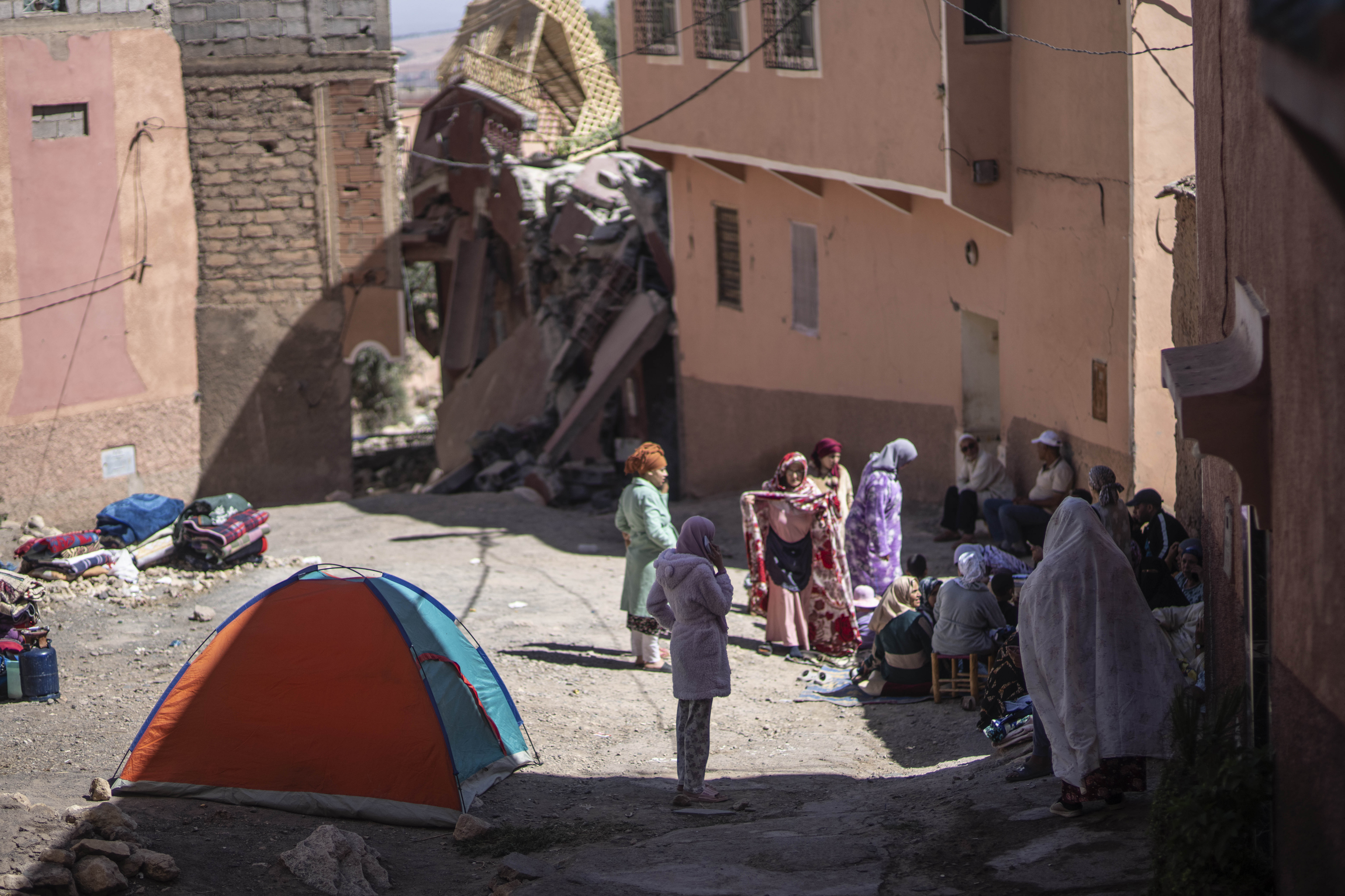 People affected by an earthquake camp outside their homes,