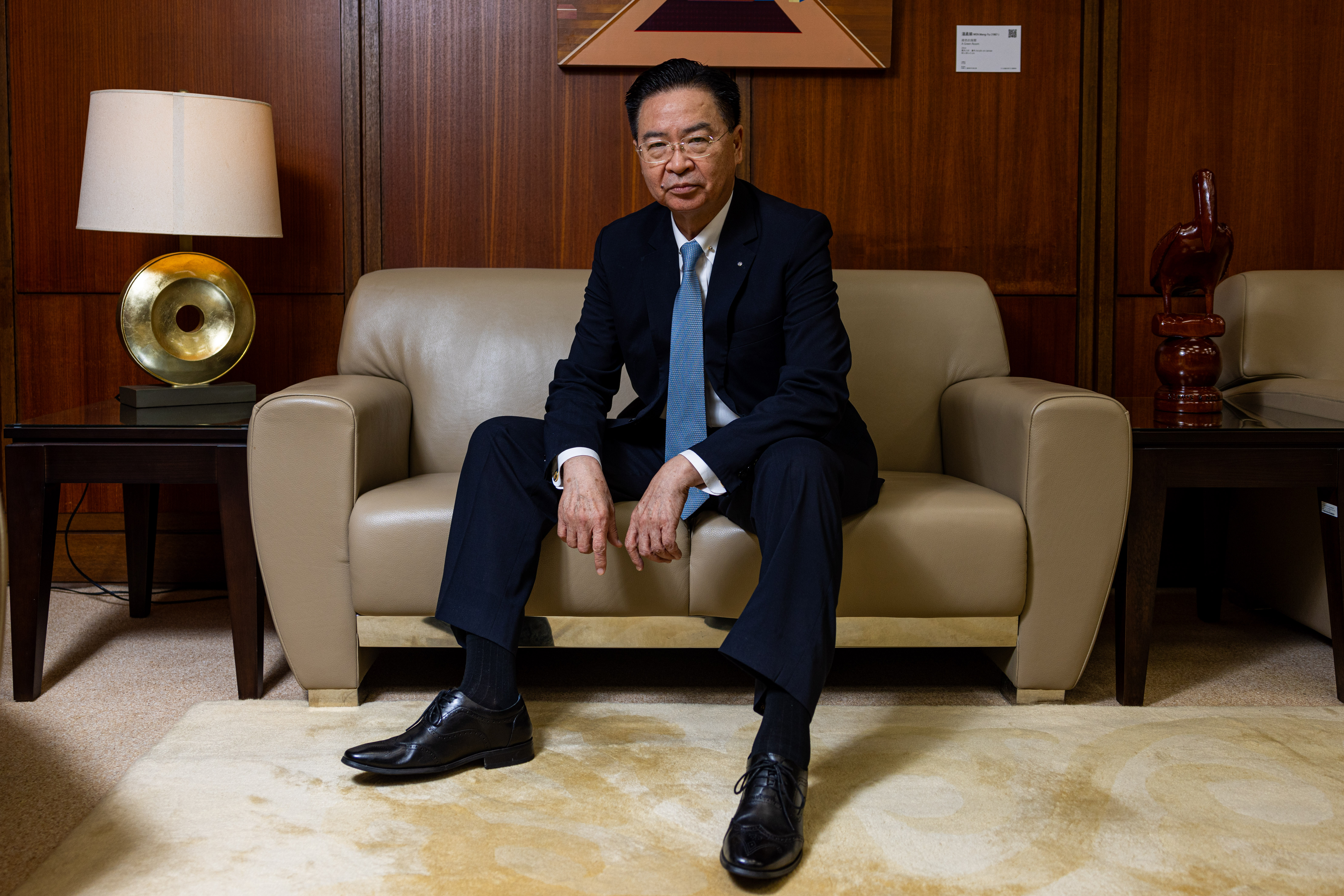 Joseph Wu seated on a beige leather sofa in his office