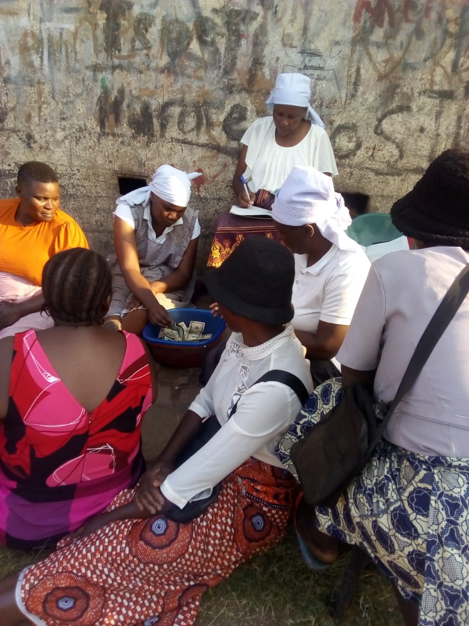A photo of a group of people sitting in a circle talking.