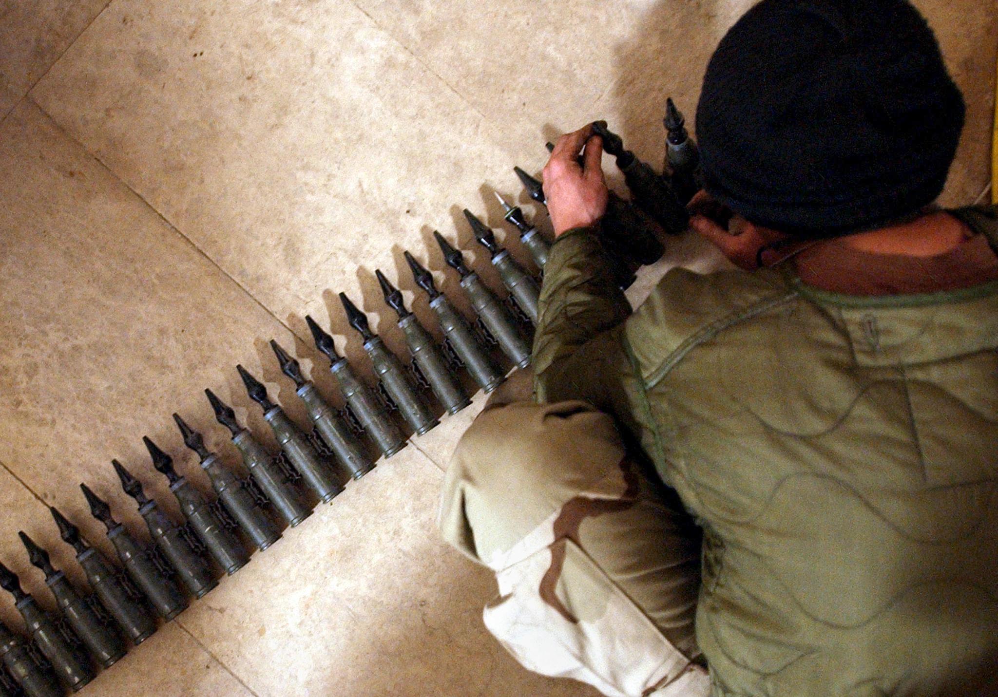 US Army Spcl. Eli Butcher of Charlie Company, from the 1-22 Battalion, 4th Infantry Division, counts 25mm rounds of depleted uranium ammunition, 11 February, 2004, at his base in Tikrit, 180 km (110 miles) north of Baghdad. The soldiers were taking inventory of the ammunition as they being to pack to leave for home in the US. AFP PHOTO/Stan HONDA (Photo by STAN HONDA / AFP)