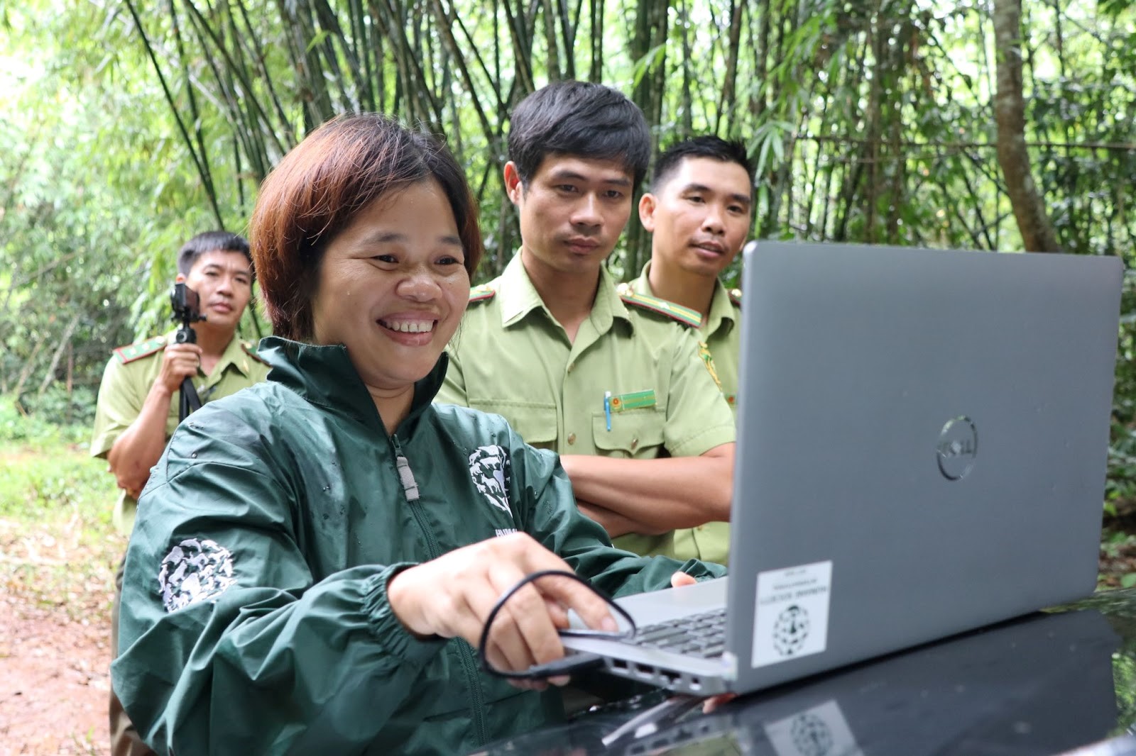 Nguyen Thi Mai shows forest rangers photos taken from a camera trap nearby at Cat Tien National Park. She has been training them on how to install and use camera traps. [Sen Nguyen/Al Jazeera]