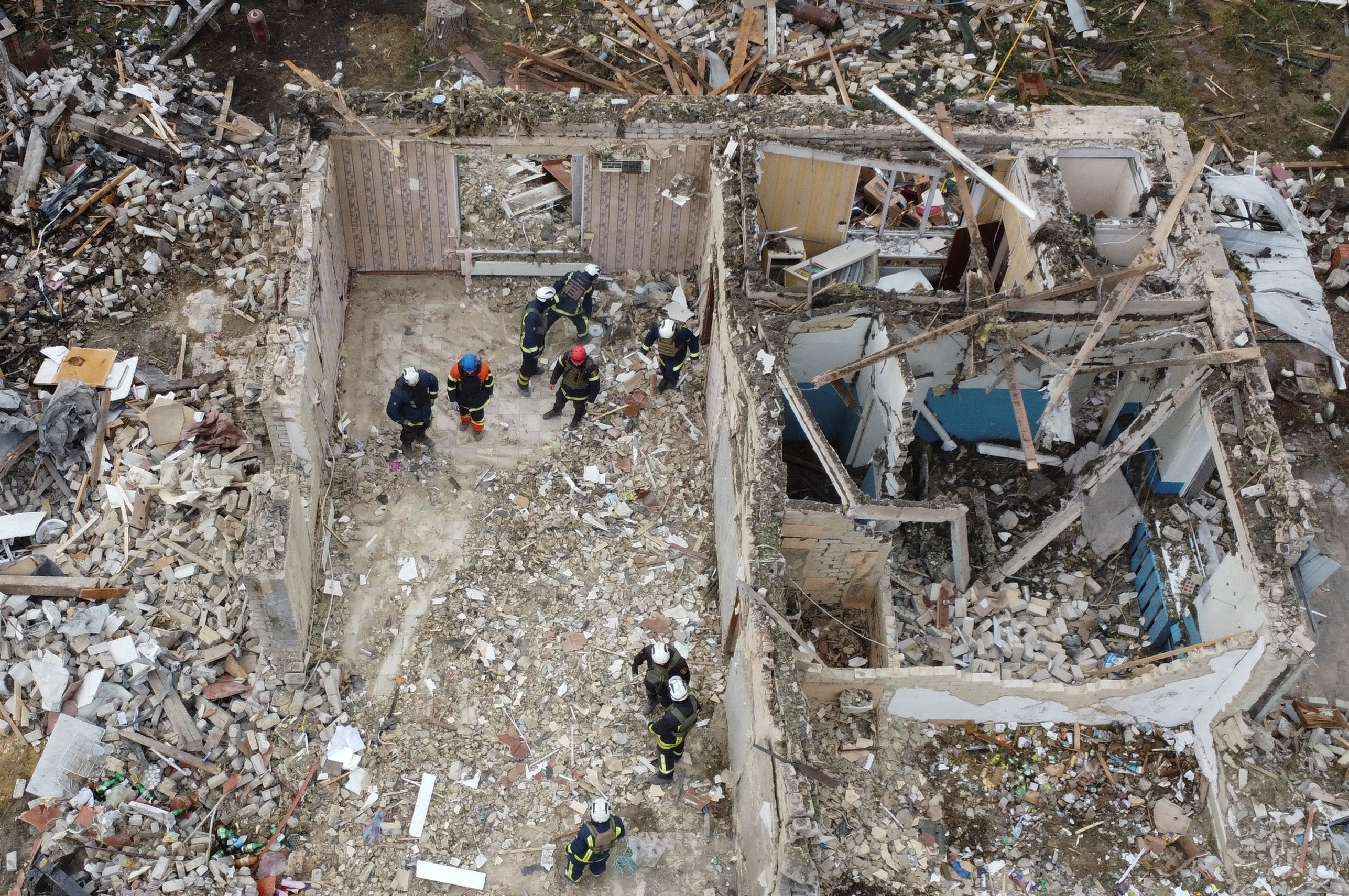 Rescues remove debris at a site of buildings of a local cafe and a grocery store, where at least 52 people were killed by a Russian missile strik