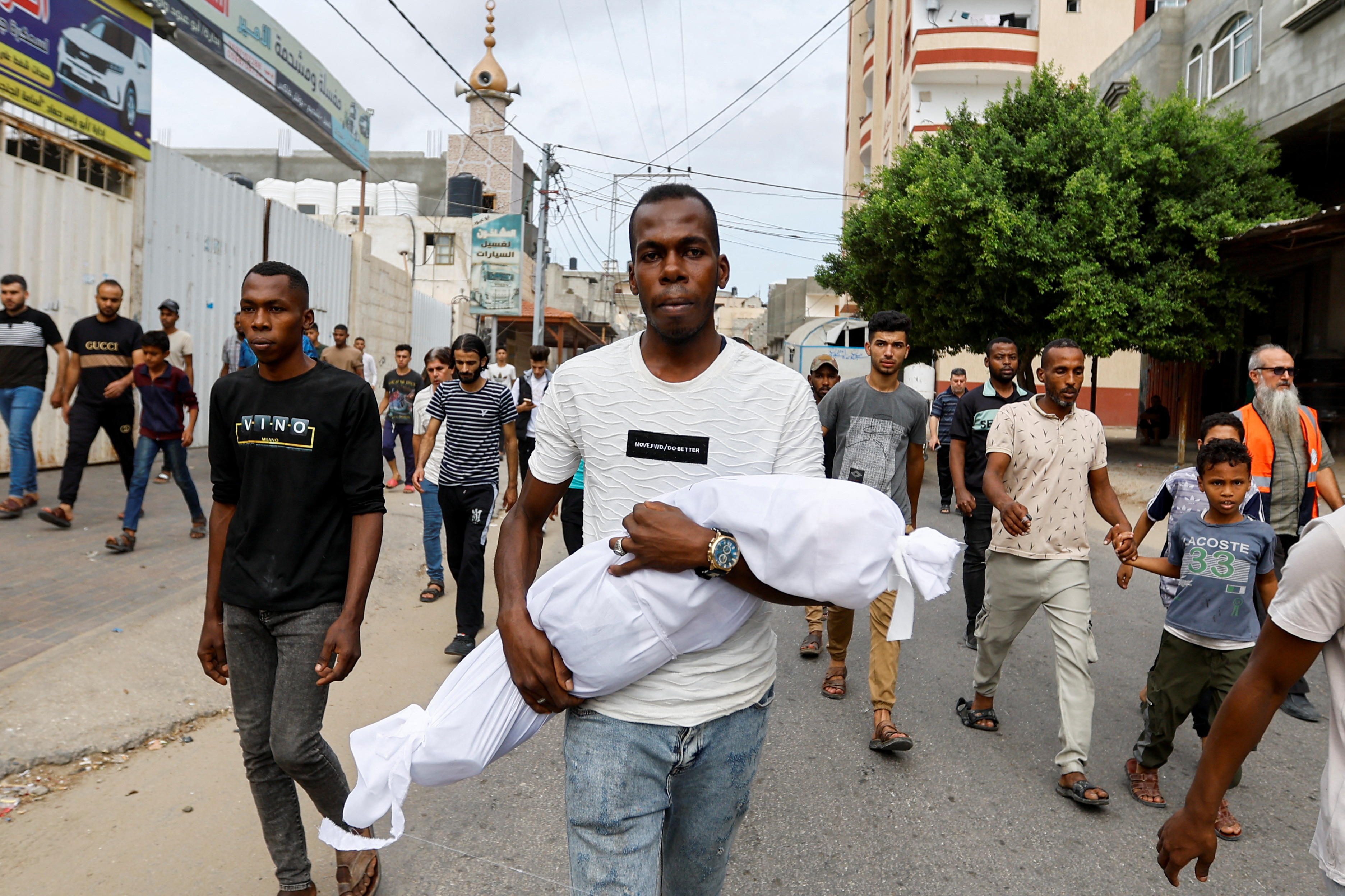 A mourner carries the body of Palestinian boy Saad Lubbad, who health officials said was killed in Israeli strikes, during his funeral in Rafah, in the southern Gaza Strip, October 9, 2023. REUTERS/Ibraheem Abu Mustafa
