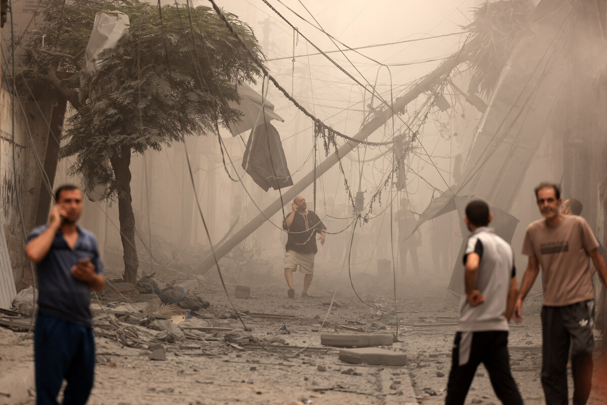 Palestinians inspect the destruction in a neighbourhood heavily damaged by Israeli airstrikes on Gaza City's Shati refugee camp