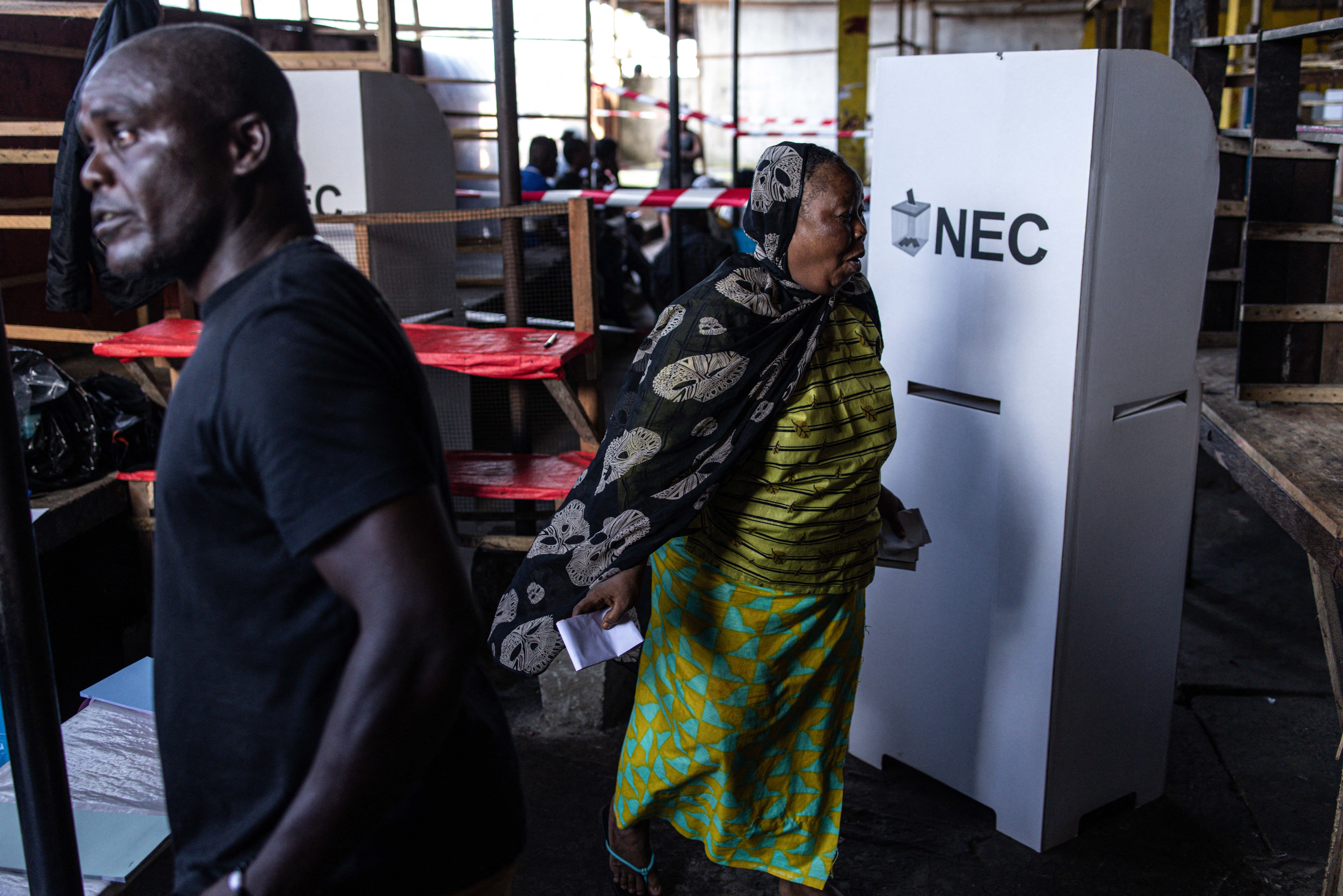A voter finishes marking her vote at a voting station in Monrovia