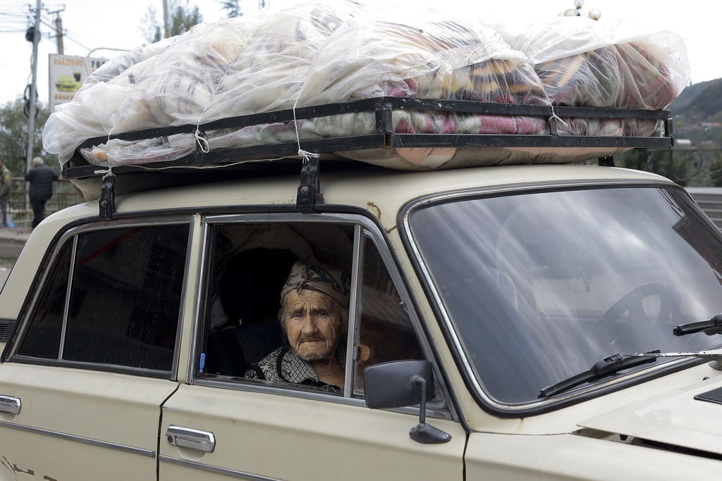 An ethnic Armenian woman from Nagorno-Karabakh sits inside an old Soviet-style car as she arrives in Goris, in Syunik region, Armenia, on September 27