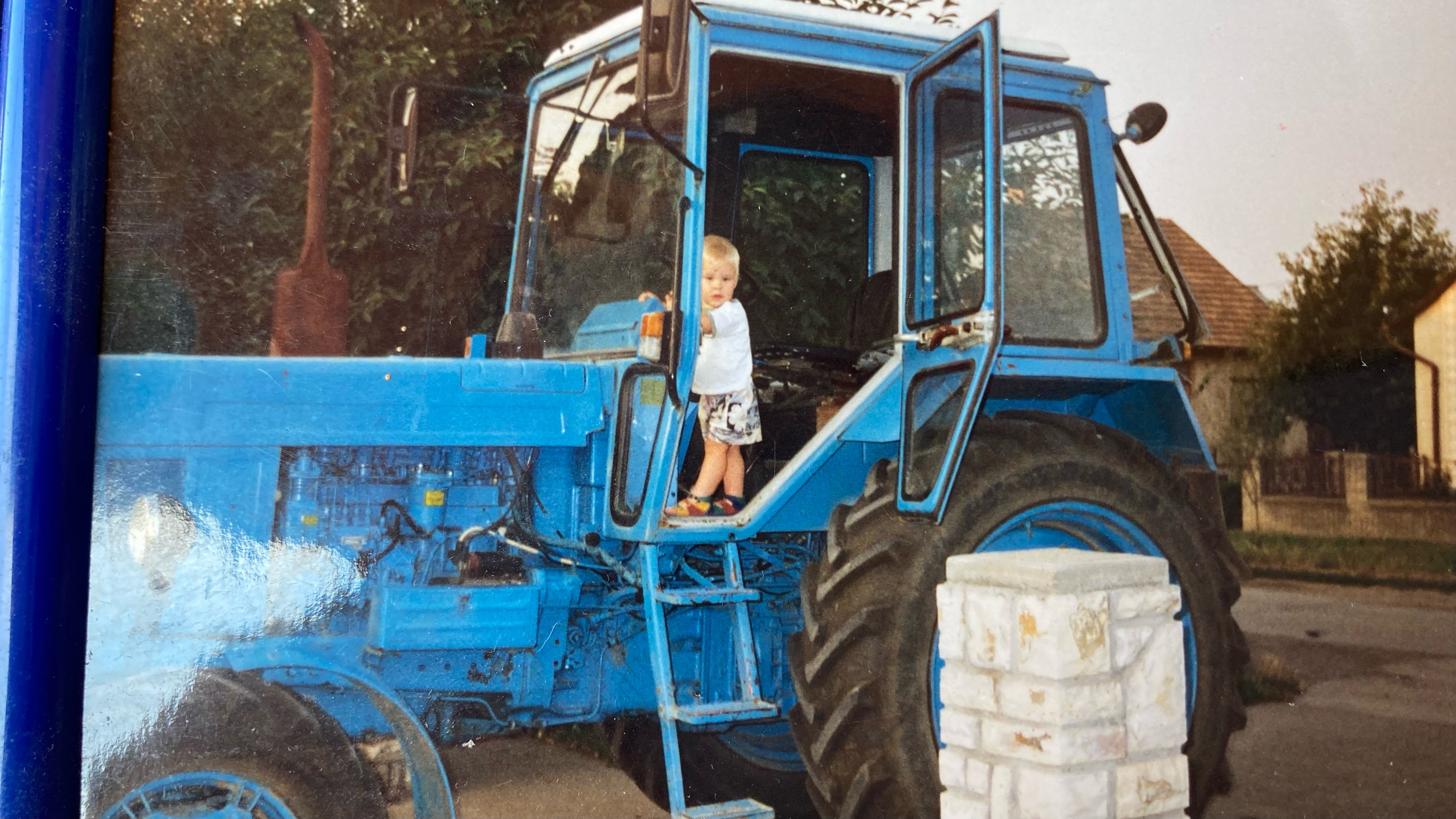 One-year-old Bálint stands on a tractor his grandparents bought from Ukraine in 1993 and brought home on a rented truck [Courtesy of Bálint Rudics]