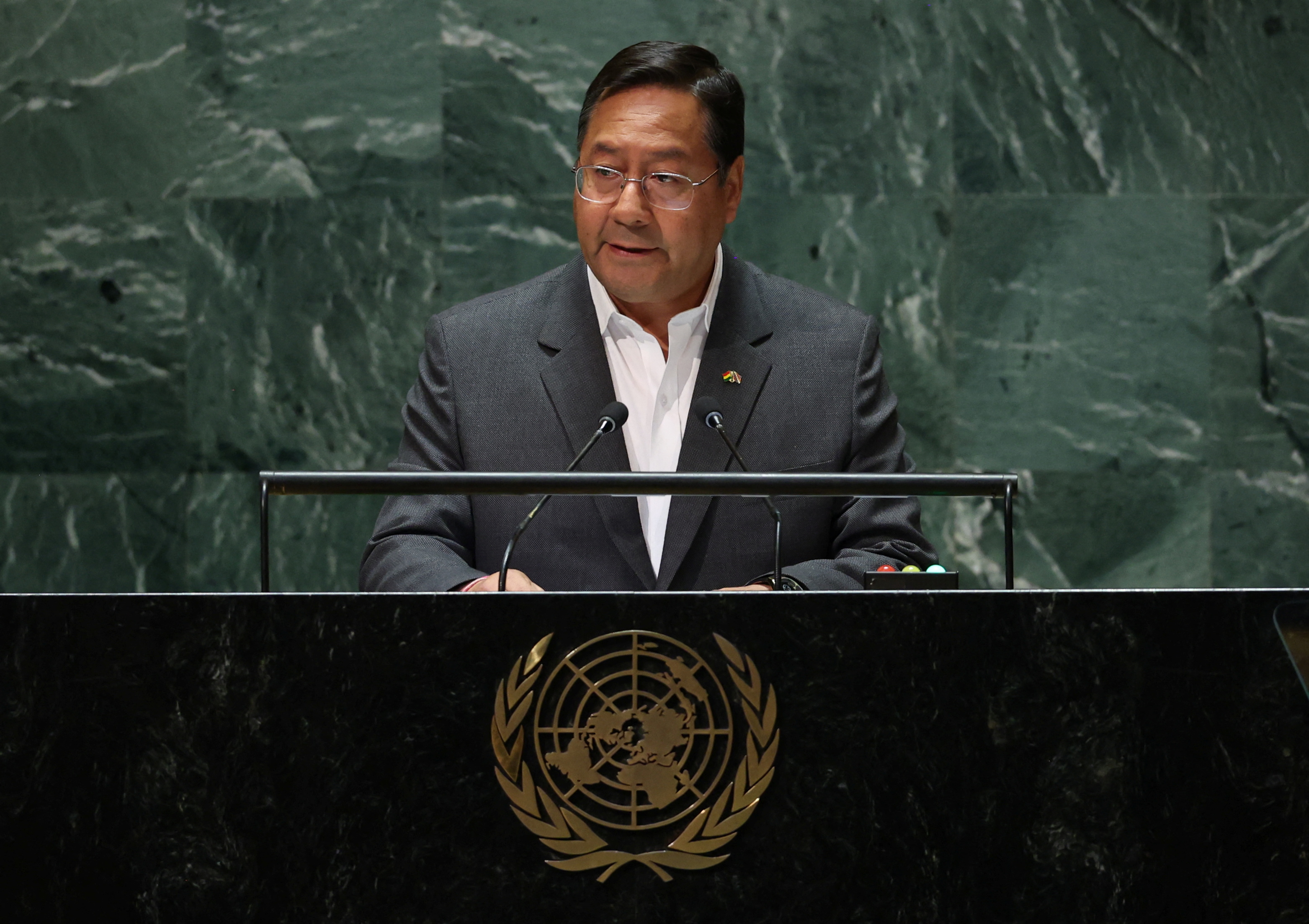 President Luis Arce stands at the UN General Assembly podium, emblazoned with the UN logo.