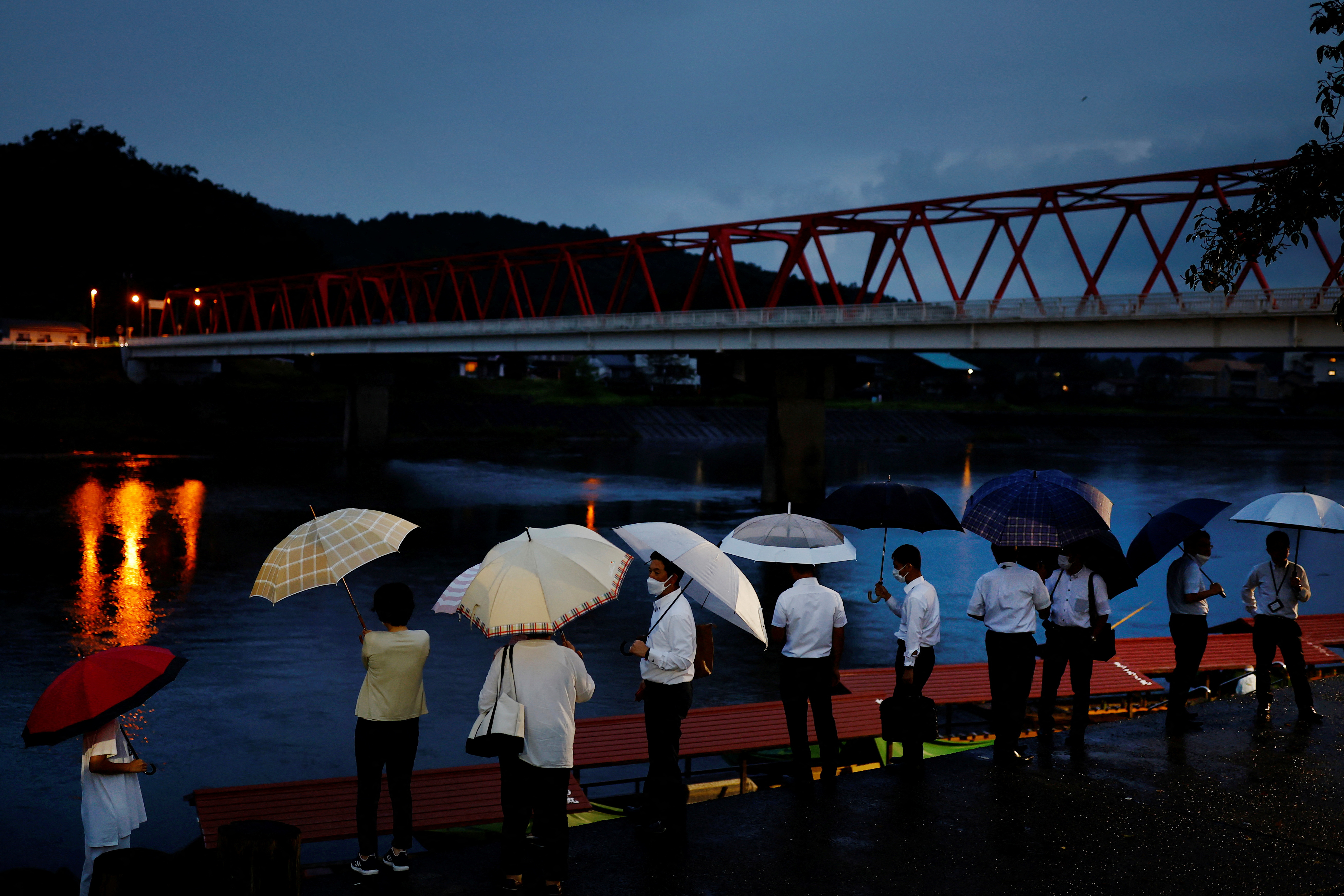 Visitors wait to board a cormorant fishing viewing boat on the Nagara River in Oze, Seki, Japan.